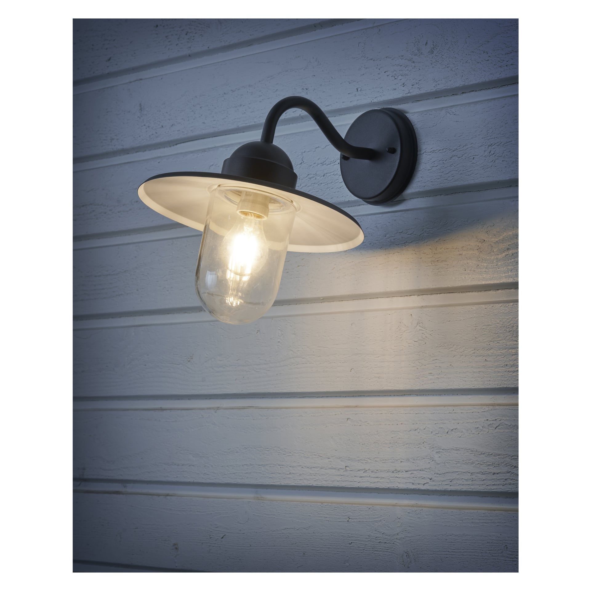 En EKVIP-vägglampa med svart arm, vit skärm och klart glasskydd är installerad på en ljusblå träpanelad vägg.