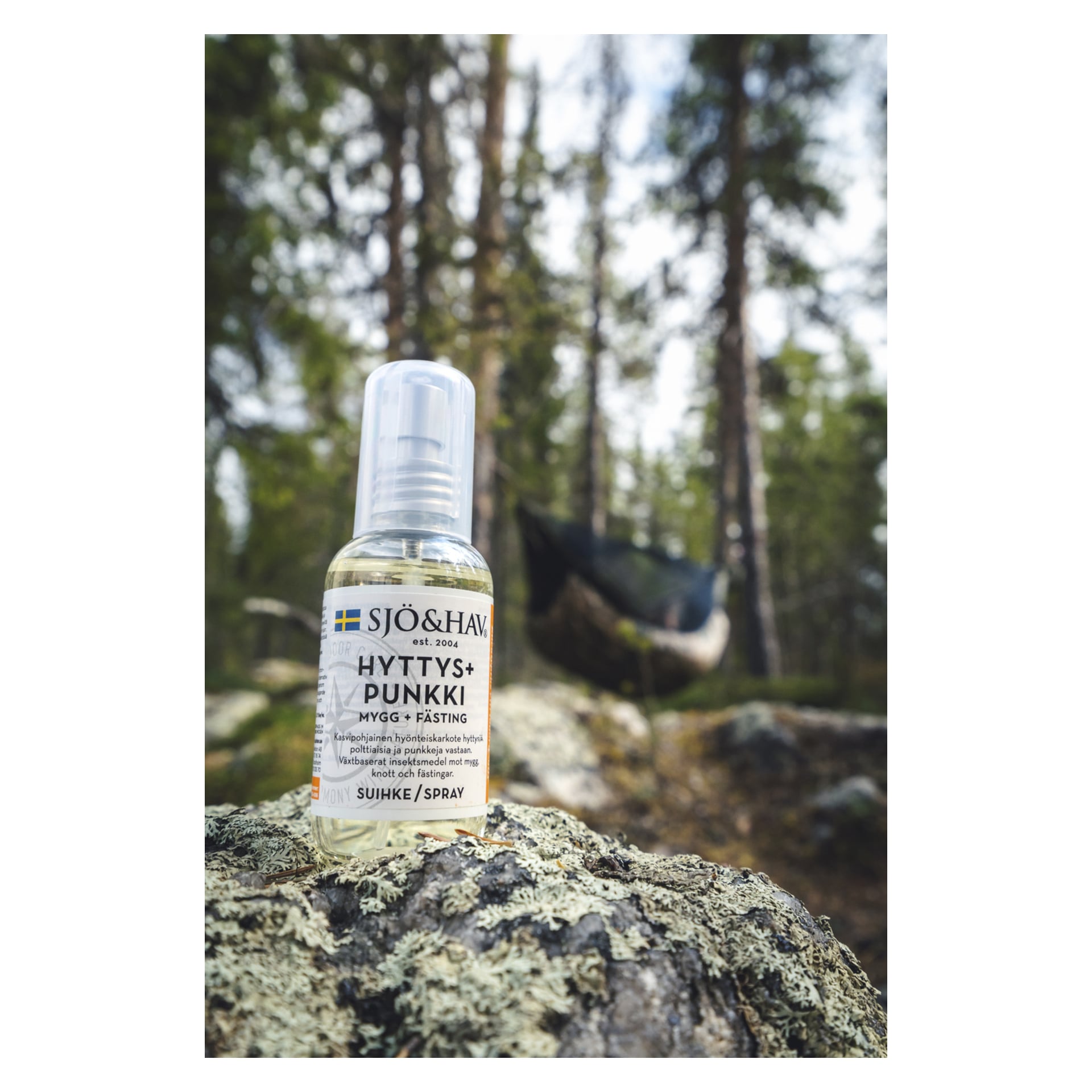 Pullo Sjö & hav Ant killer Hyttys+Punkkia lepää sammaleen peittämän kiven päällä metsässä, puiden ympäröimänä ja himmeästi näkyvällä riippumatolla sumeassa taustassa.