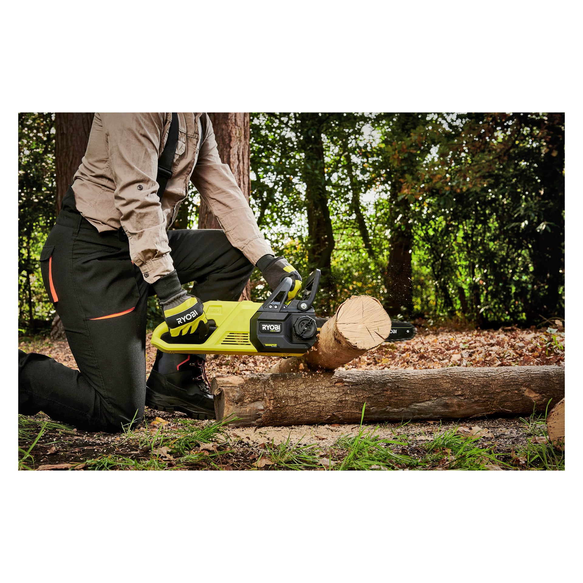 En person knäböjer utomhus med en Ryobi One+ motorsåg RY18CSX30A-0 för att såga en stock som vilar på en annan, klädd i handskar, stövlar, arbetsbyxor och en långärmad tröja bland träd och fallna löv.