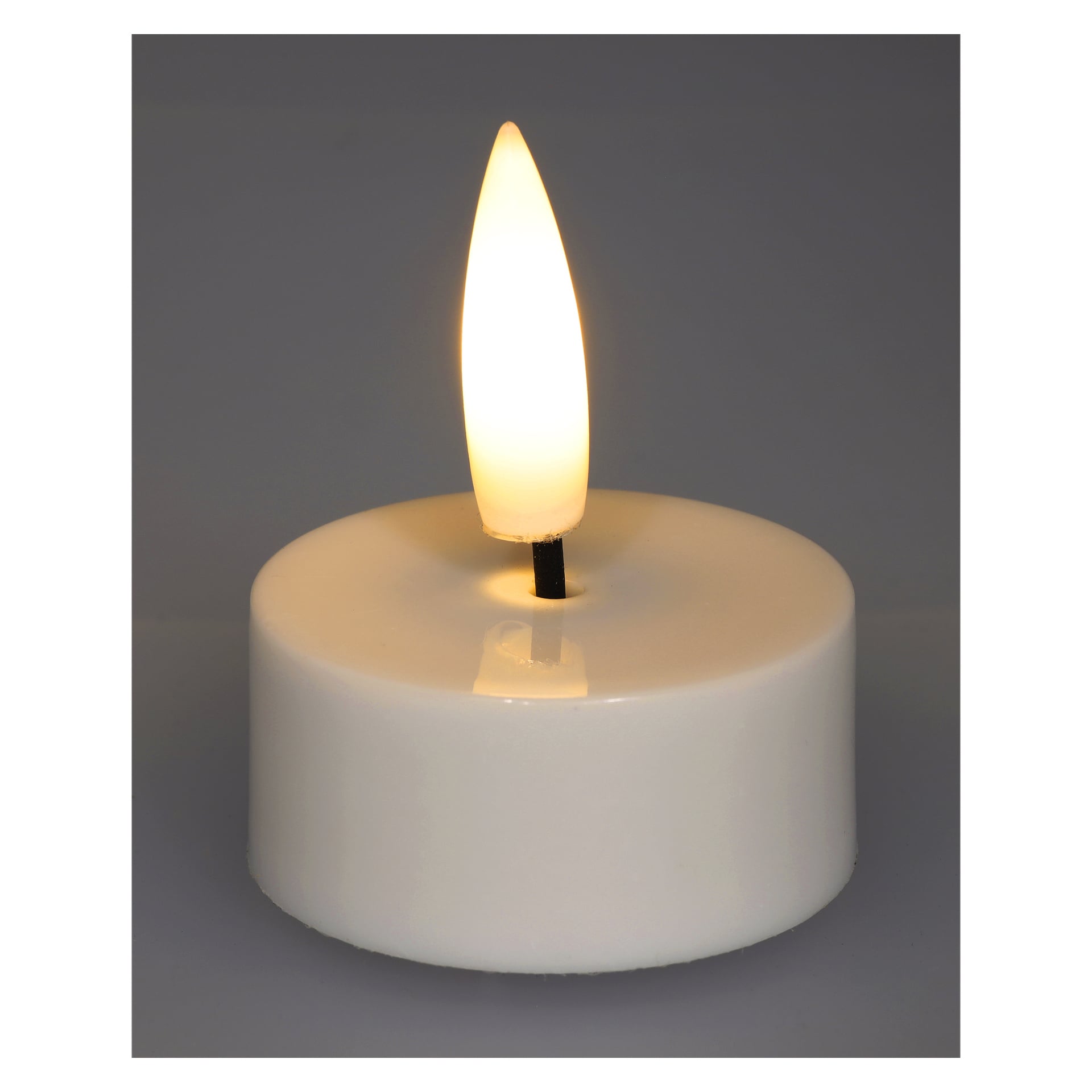 Ett vitt, runt Menuett LED-teljus från en fyrpack står på en neutral grå yta. Det batteridrivna ljuset har en plastlåga som ger ifrån sig ett mysigt gult sken.