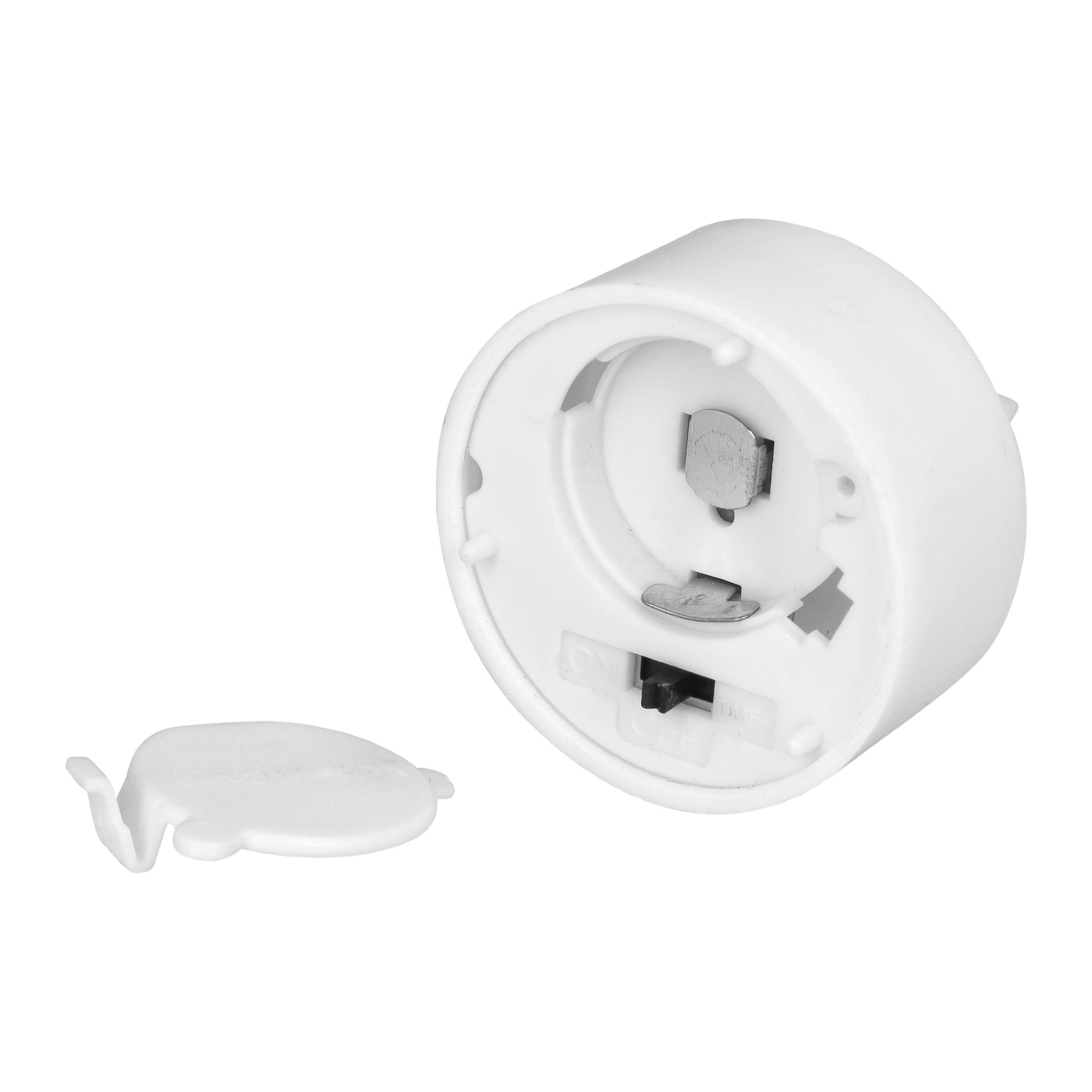 Ett runt vitt plast-LED-teljus från Menuett är avbildat med batterifacket öppet, vilket exponerar metallkontakterna inuti. Det avtagbara skyddet placeras bredvid. Den här produkten kommer i ett paket med fyra var.