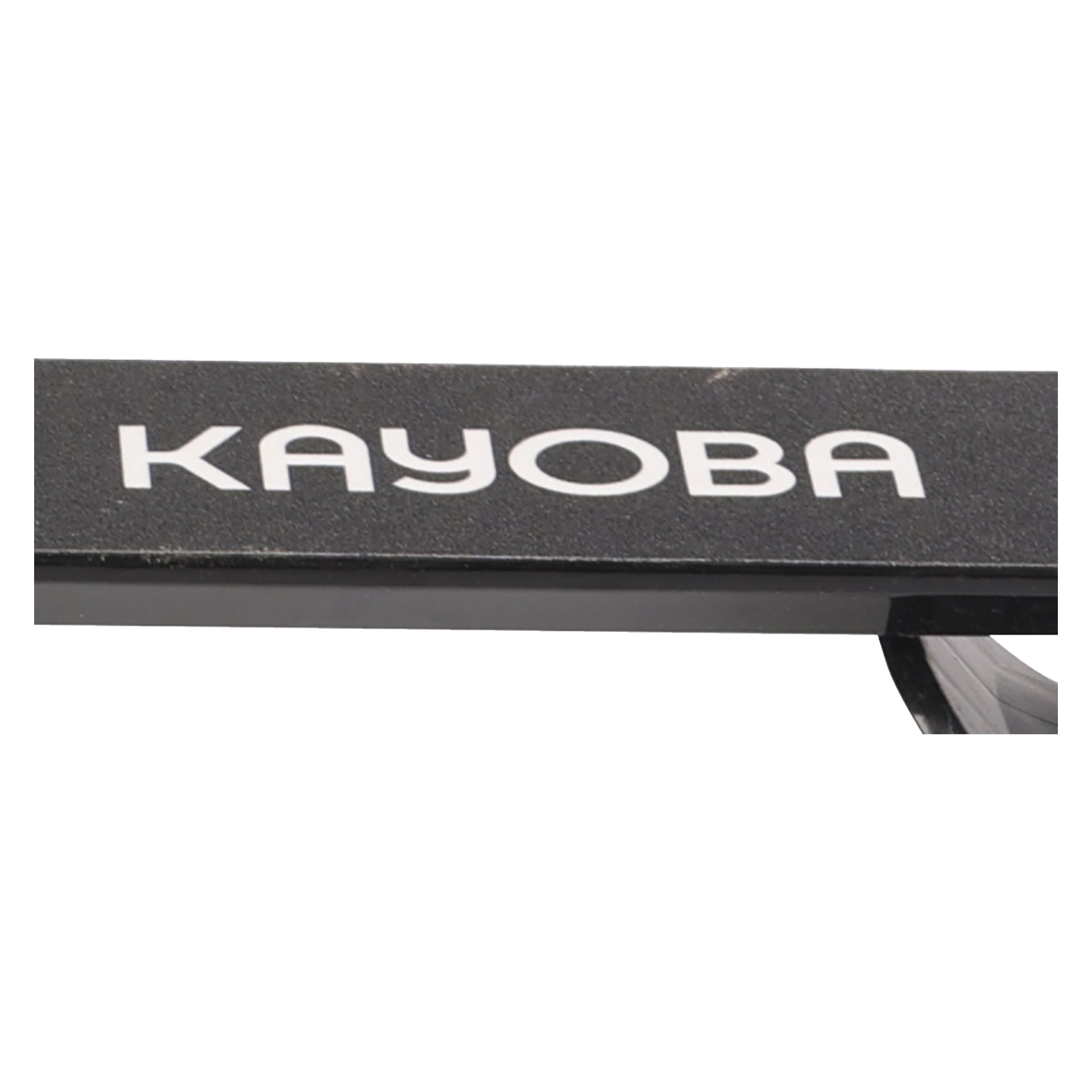 En närbild av den svarta ytan på den hopfällbara snöscootern Kayoba, med ordet "Kayoba" i framträdande vita bokstäver. Ytan har ett lätt texturerat utseende, och en del av den böjda kanten syns längst ner.