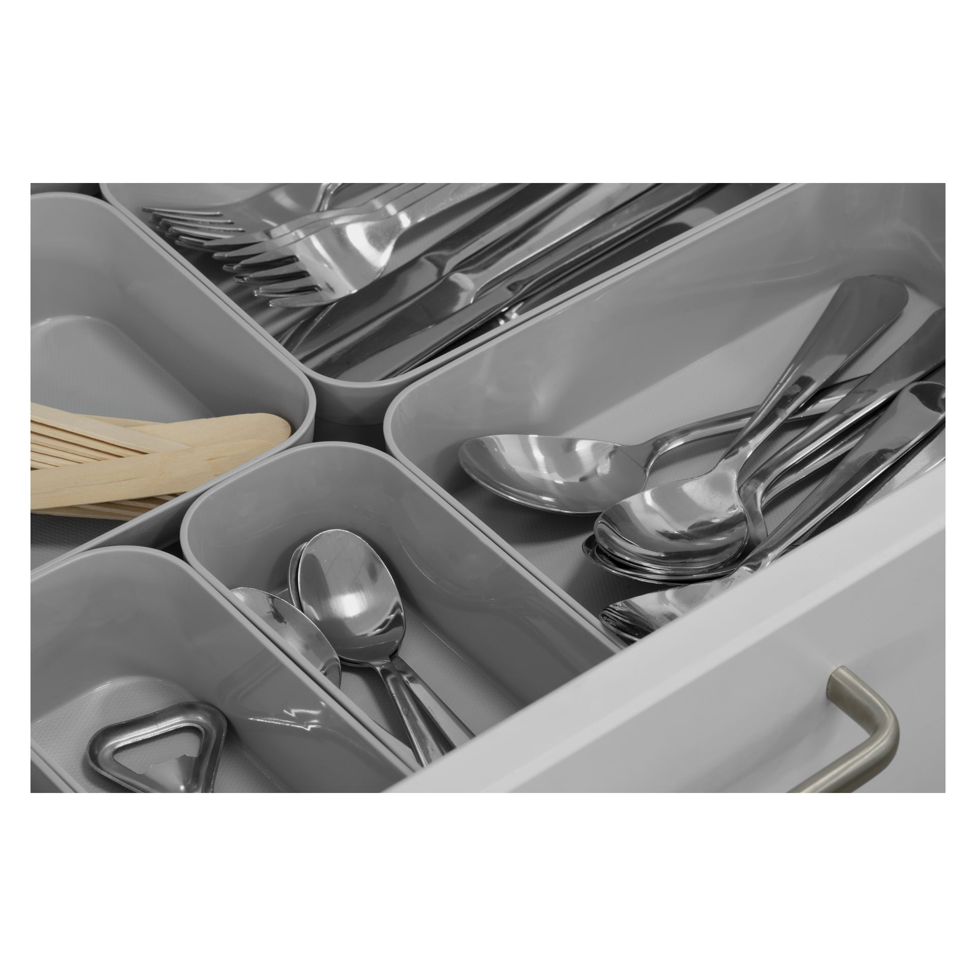En kökslåda är öppen och visar en grå Hard Head Drawer-insats som prydligt delar skedar, gafflar och knivar i individuella fack. Ett träredskap och ett metallköksredskap finns också bland besticken. Lådan har ett silverhandtag.