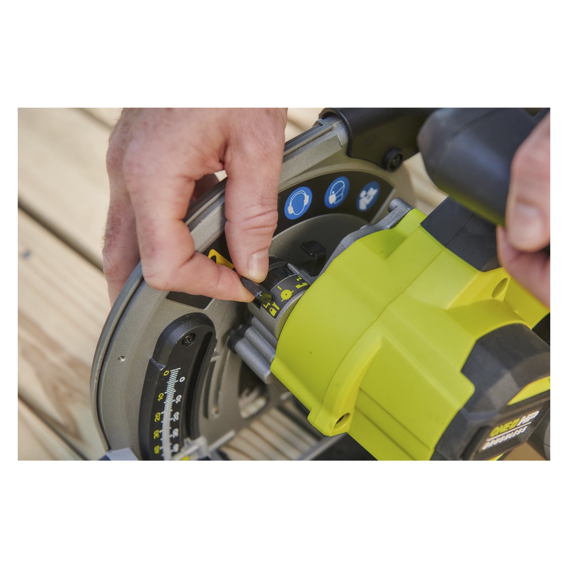 Någon ställer in vinkeln på en Ryobi One+ HP batteridriven sänksåg och styrskena RPLS18X-0, vilket matchar en gul indikator med den markerade guiden. Den gröna och grå sågen vilar på en träyta, med personens händer synliga.