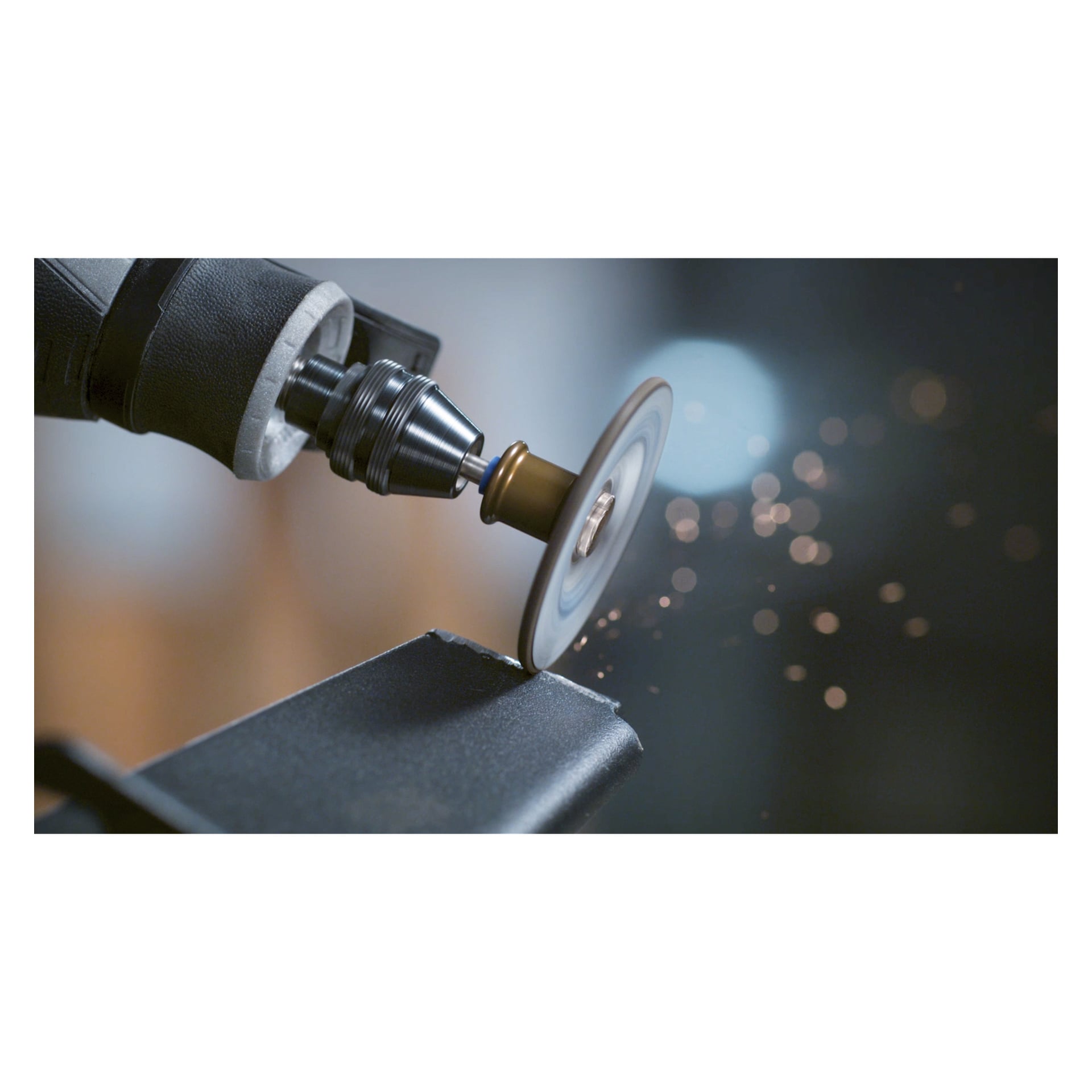 Ett Dremel-roterande verktyg utrustat med en SC541 SpeedClic-slipskiva (2-pack) används för att slipa metall och producerar synliga gnistor. Fokus ligger på verktyget och metallbiten, med en suddig bakgrund för att dra uppmärksamheten till handlingen.