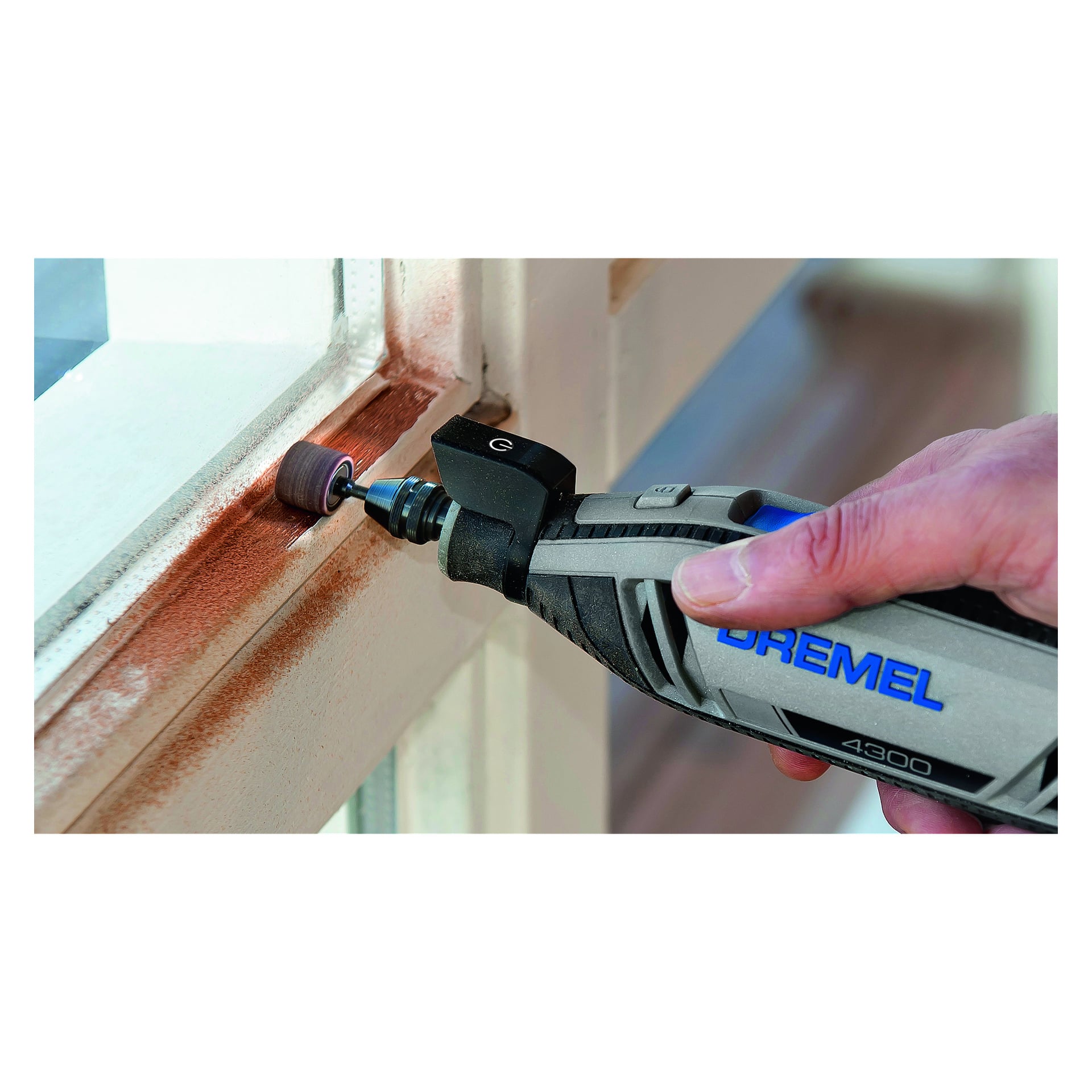 Man slipar kanten på en träram med ett Dremel-slipband från en 6-pack.
