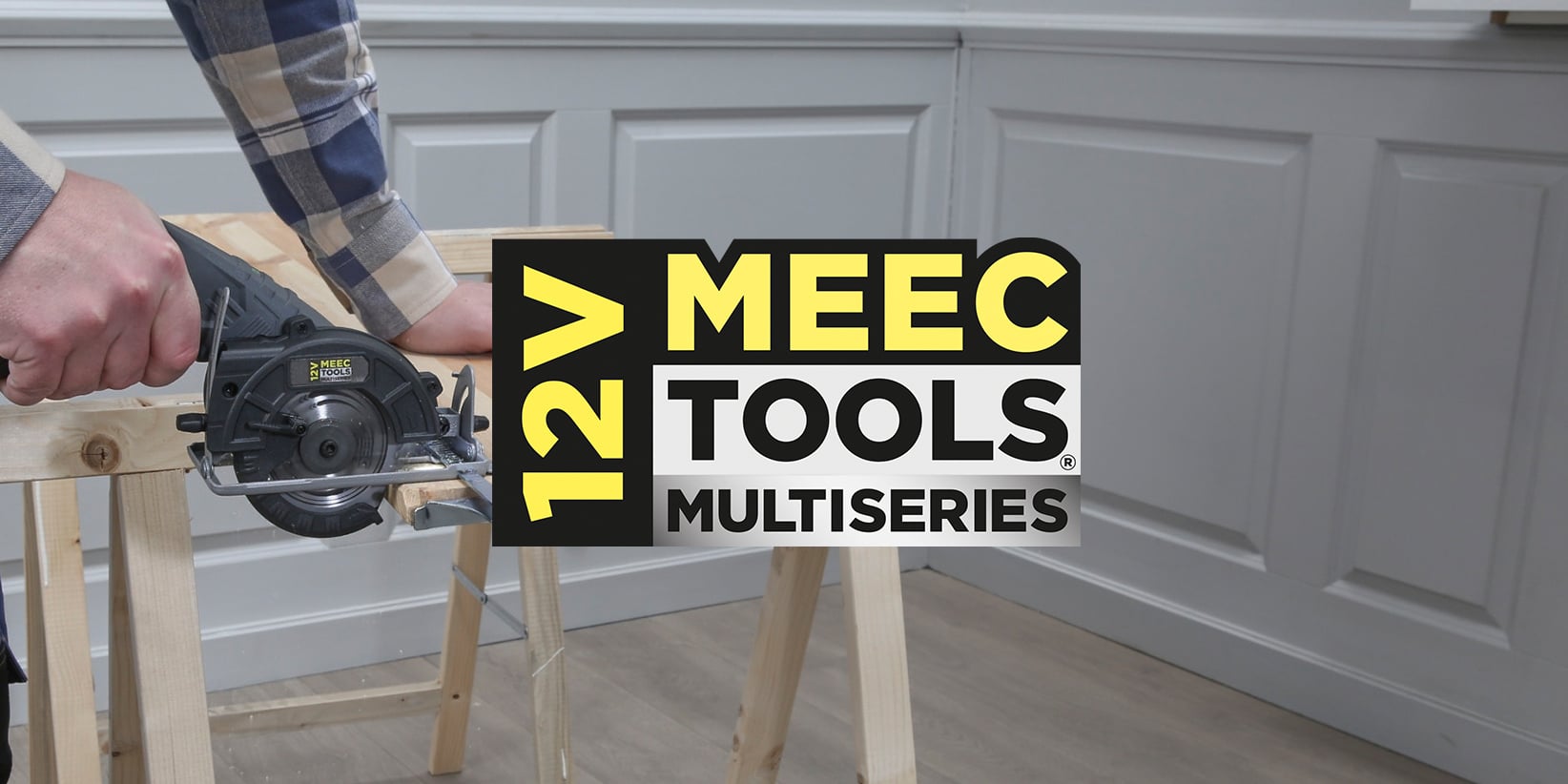 Någon i rummet kapar en träskiva med en MEEC Tools 12-volts cirkelsåg; MEEC Tools Multiseries-logotypen är i mitten.