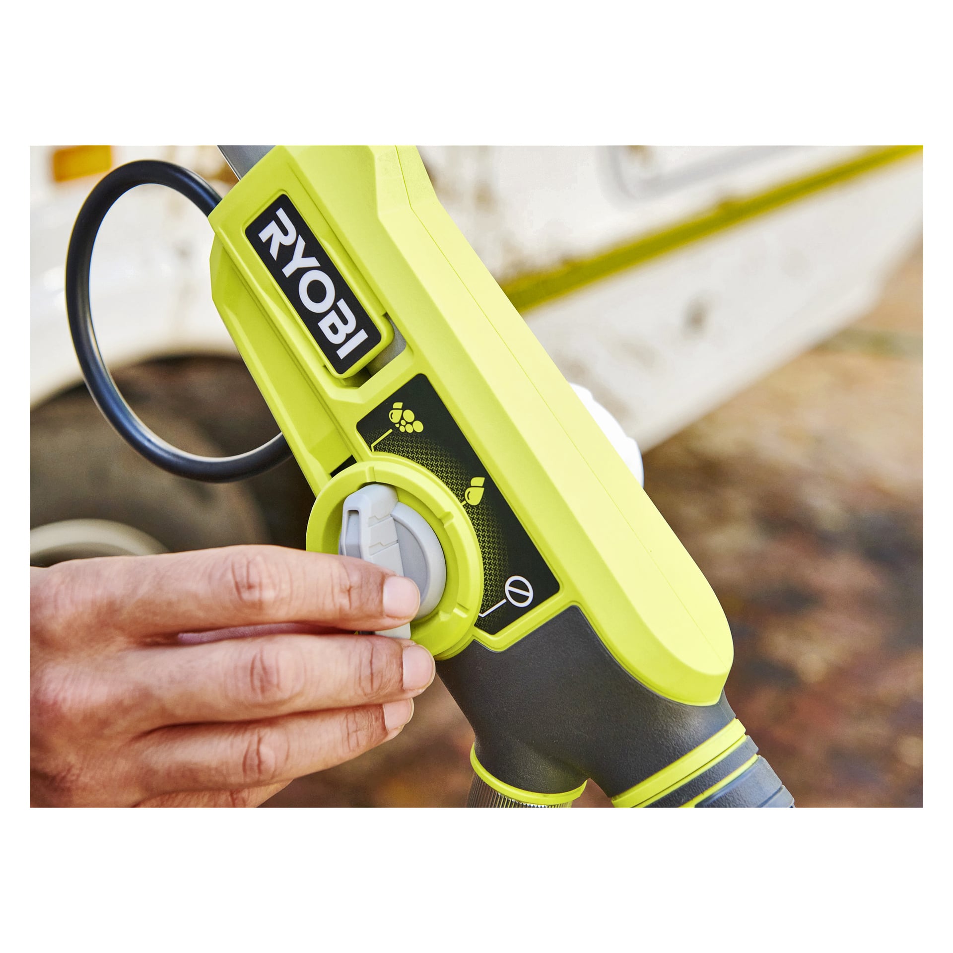En hand vrider ratten på en grön Ryobi One+ roterande tvättborste RWTS18-0, vilket betonar justeringen av dess kontrollinställningar. Borsten visar en svartvit Ryobi-logotyp tillsammans med olika modeikoner.