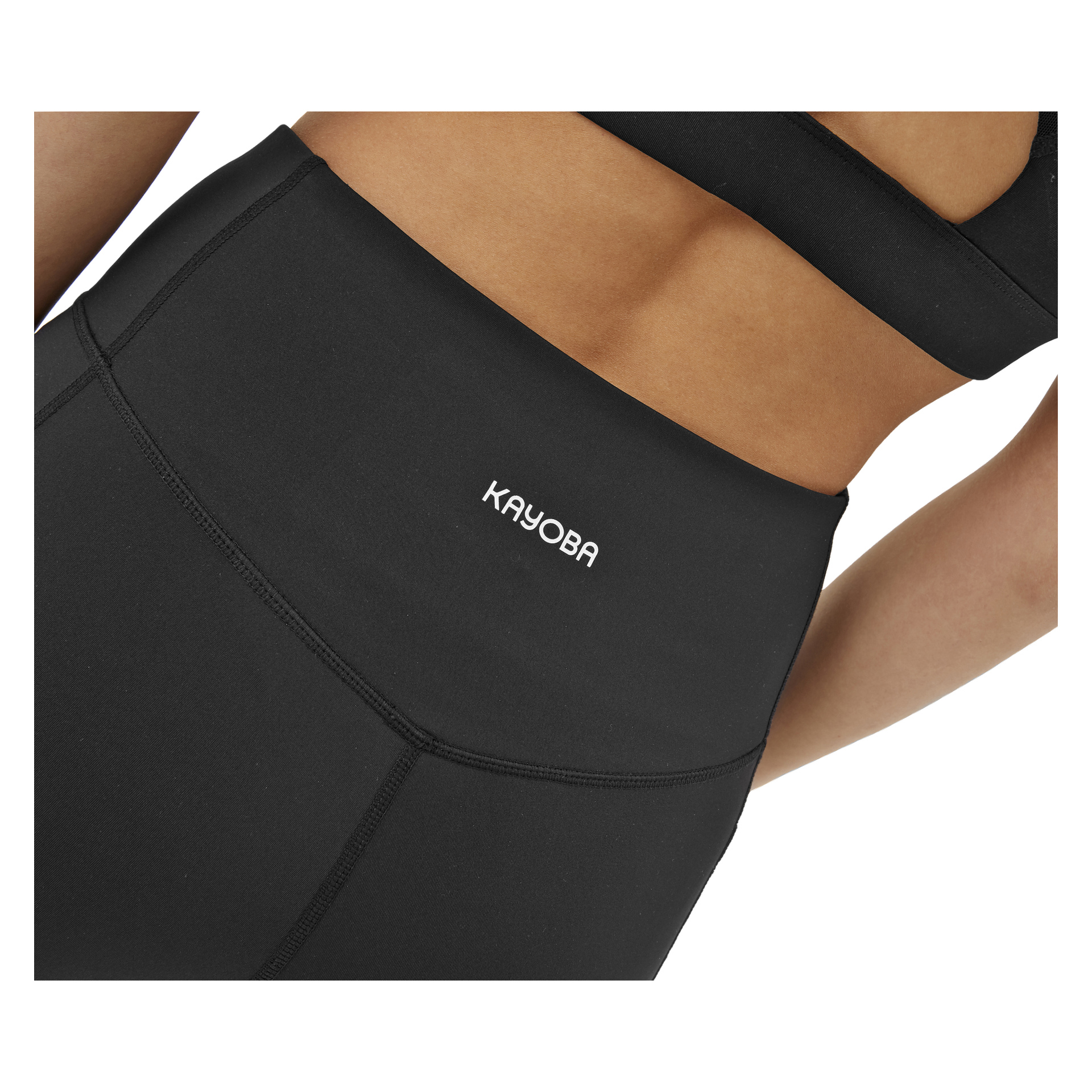 Närbild på en person klädd i svarta Kayoba Tights damkläder i Boston, matchad med en svart sport-bh. Leggingsen har "Kayoba" tryckt i vitt på midjebandet.