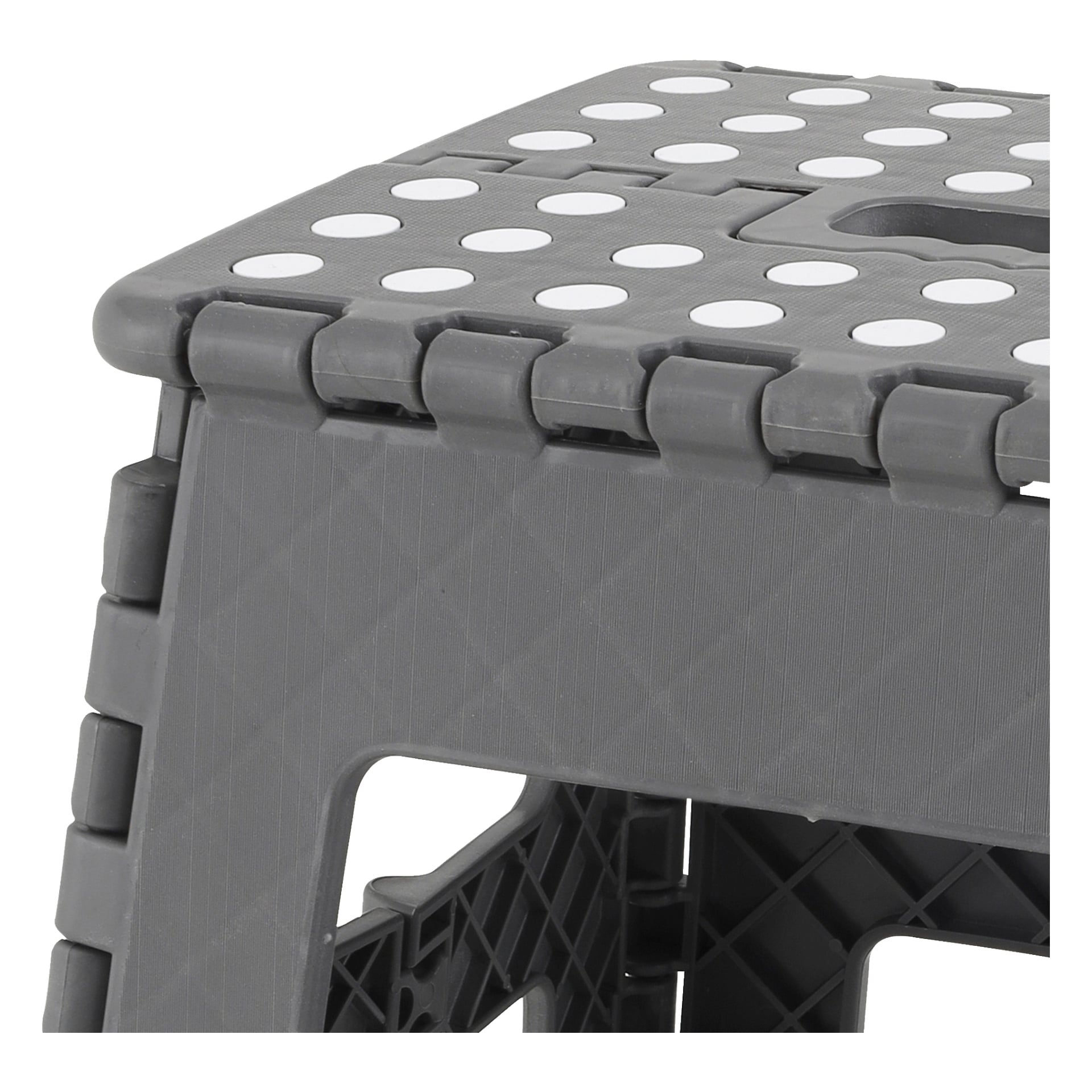 Närbild av Hard Head Folding Stool, som visar dess grå plastkonstruktion med texturerad topp, vita runda halkfria prickar och en framträdande gångjärnsmekanism längs övre kanten.