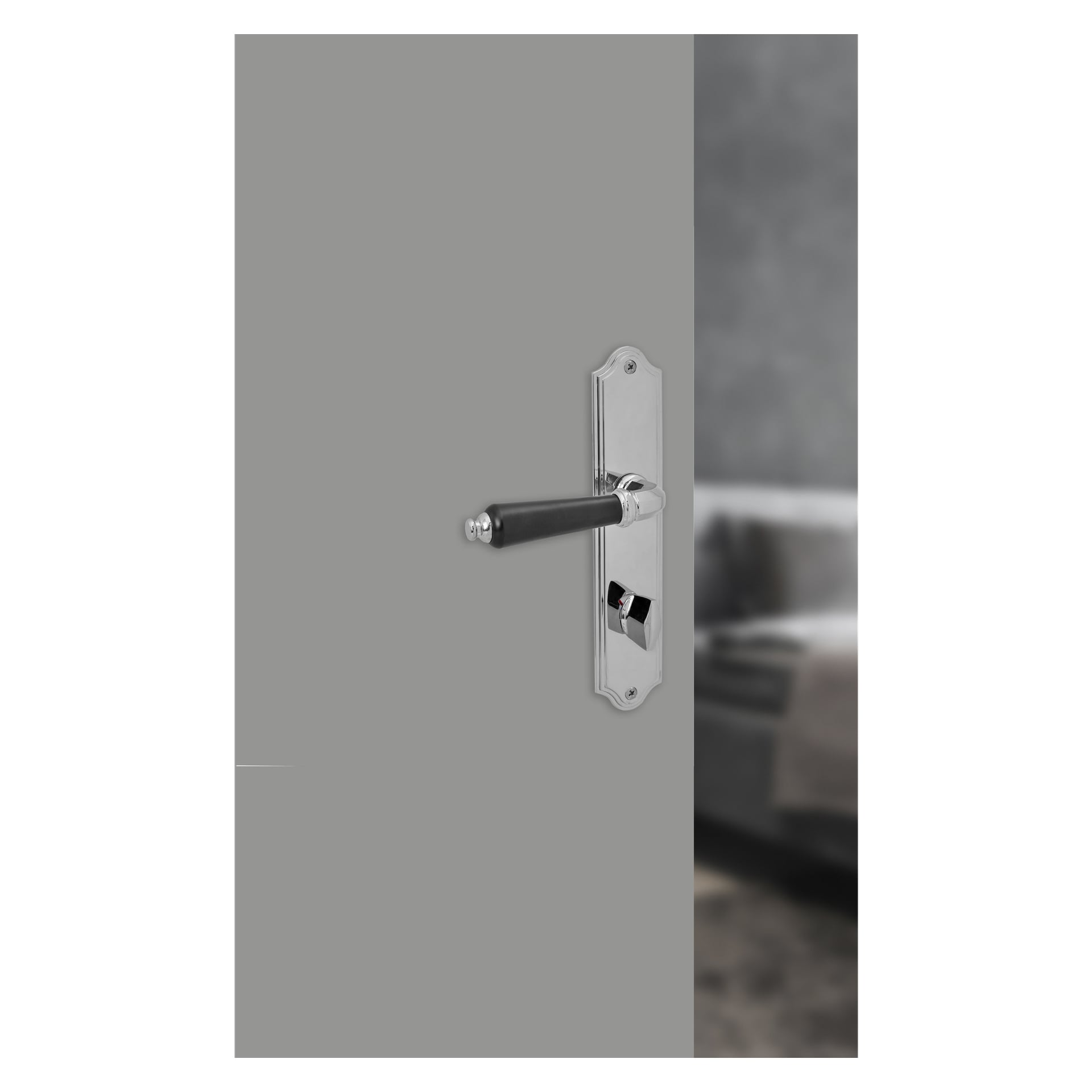 Eine detaillierte Ansicht des Hard Head Innentürgriffs mit einem WC-Knauf in Chrom, der die glänzende Chromoberfläche und den kontrastierenden schwarzen Hebel an einer grauen Tür zeigt. Die halb geöffnete Tür enthüllt einen unscharfen Raum mit einem Sofa in der Ferne.