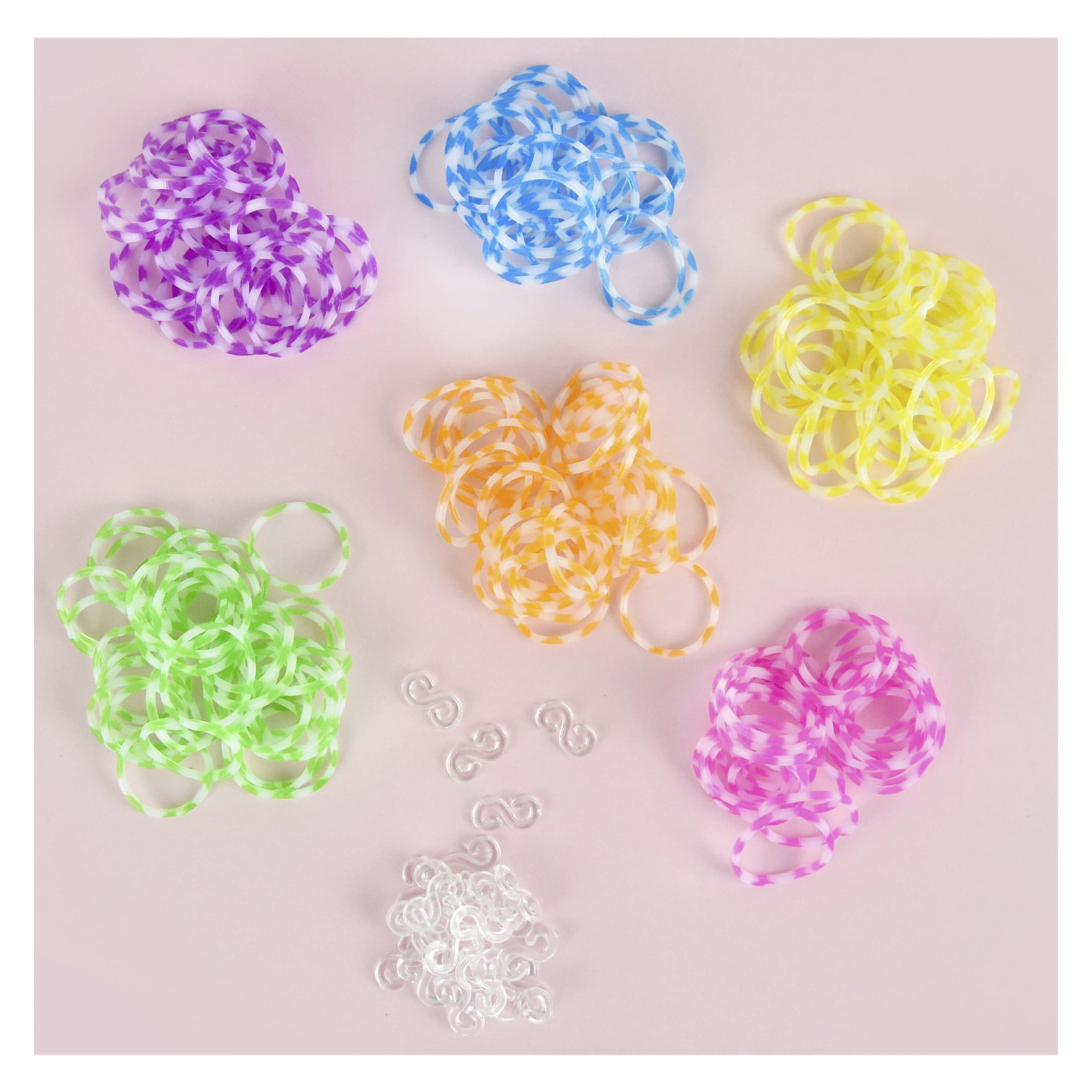 Seks hauger med Loom Bands 1200-pakke fra Robetoy i lilla, blått, gult, grønt, oransje og rosa er lagt ut i en sirkel på en rosa overflate med klare S-spenner og ensfargede bånd i midten.