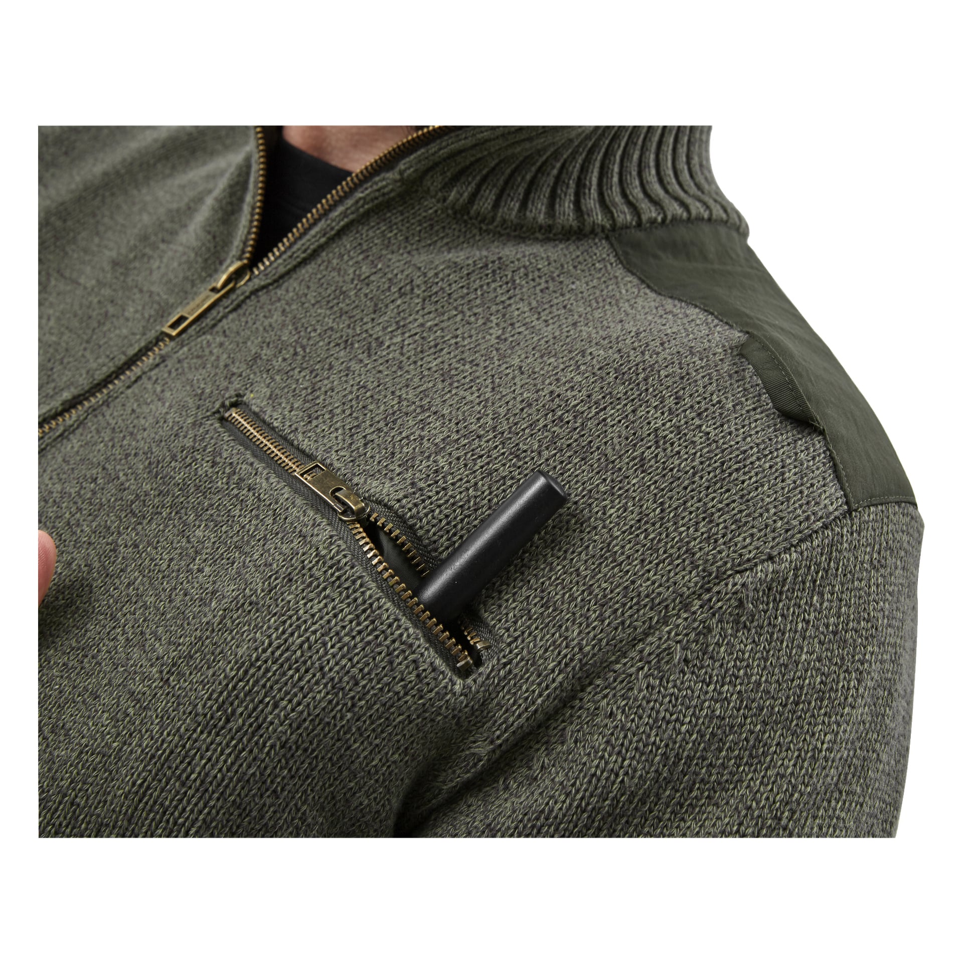 Närbild av någon klädd i den gröna Kayoba Outdoor Knitted Men's Hunting Sweater Cannock. En penna är delvis synlig i bröstfickan nära en guldfärgad dragkedja, och bara en del av bärarens hals och haka syns.