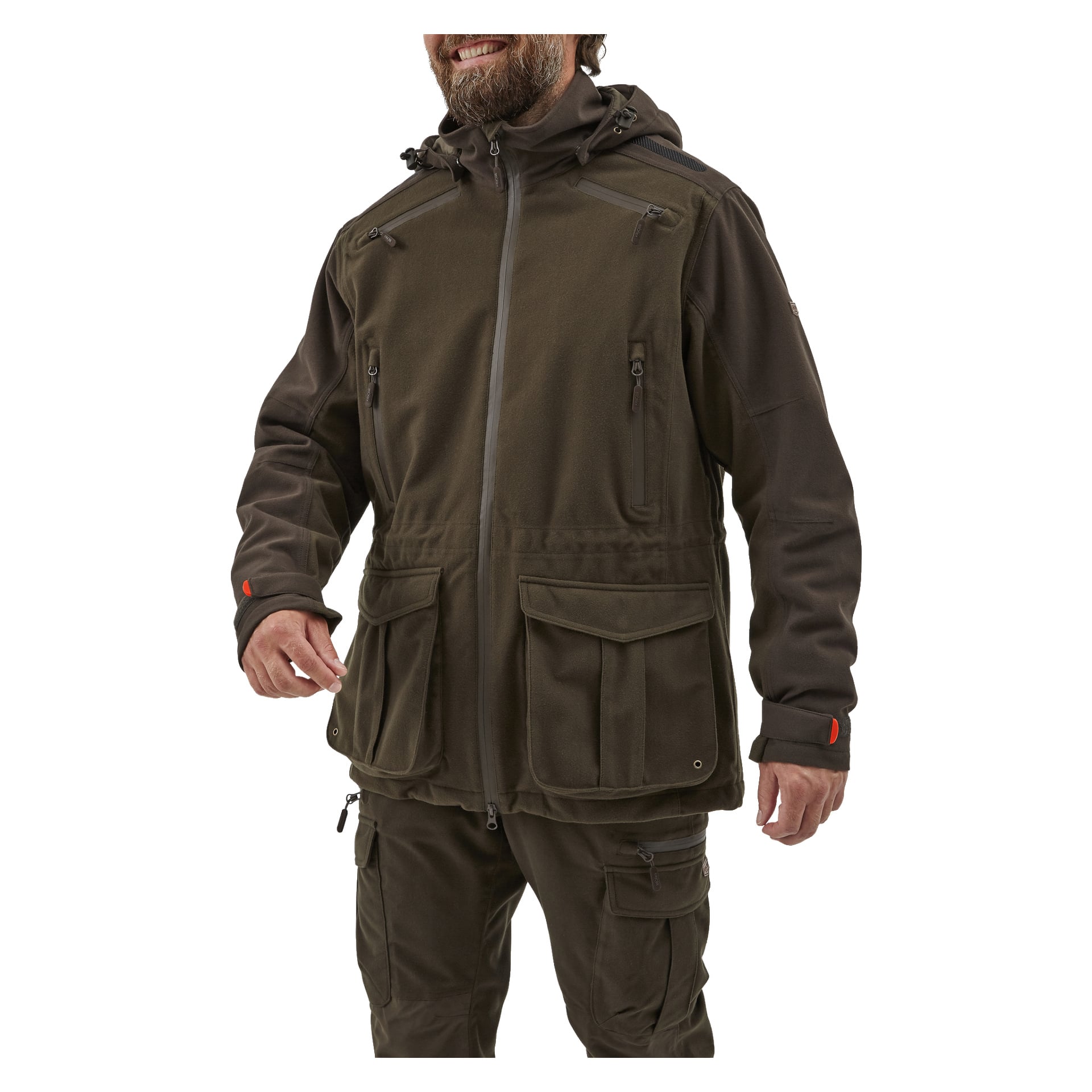 En man visar Kayoba Outdoor Men's Hunting Jacket Cannock Superior, en mörkgrön dragkedjajacka med flera fickor, huva, hög krage och orange detaljer på muddgarna, tillsammans med matchande cargobyxor.