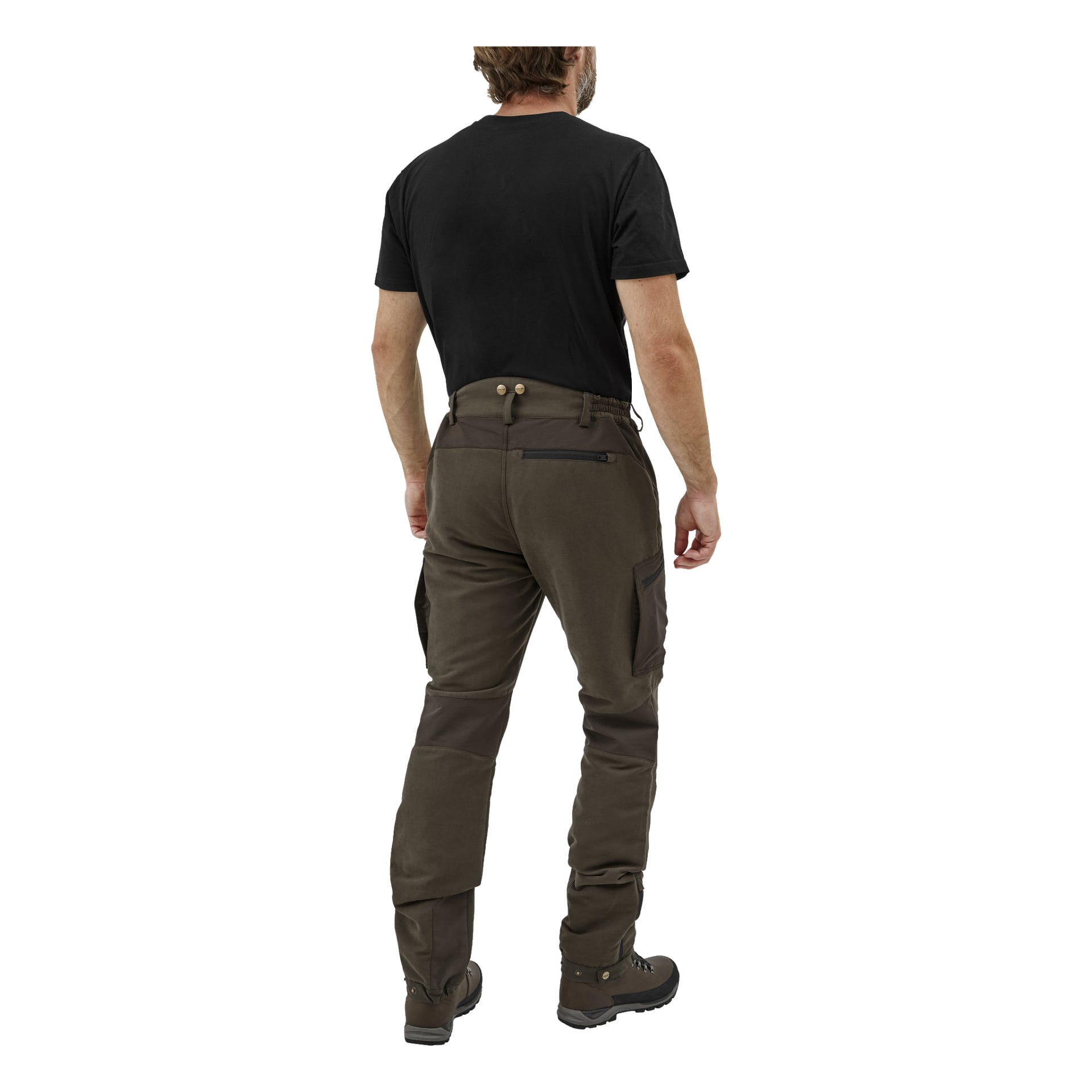 En man syns bakifrån, klädd i svart t-shirt, bruna Kayoba Outdoor Men's Grimsö jaktbyxor med cargofickor och förstärkta knän samt bruna vandringskängor. Hans armar vilar naturligt vid sidorna.