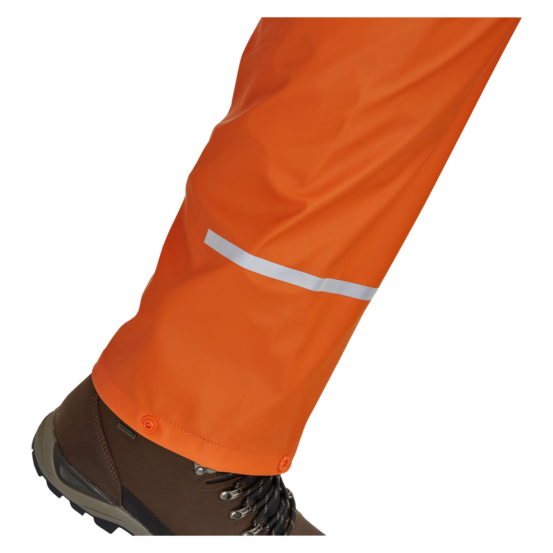 Eine Person trägt braune Wanderschuhe sowie leuchtend orangefarbene Bluewear-Regenhosen mit einem reflektierenden silbernen Streifen nahe dem Knöchel und Druckknöpfen an den Manschetten.