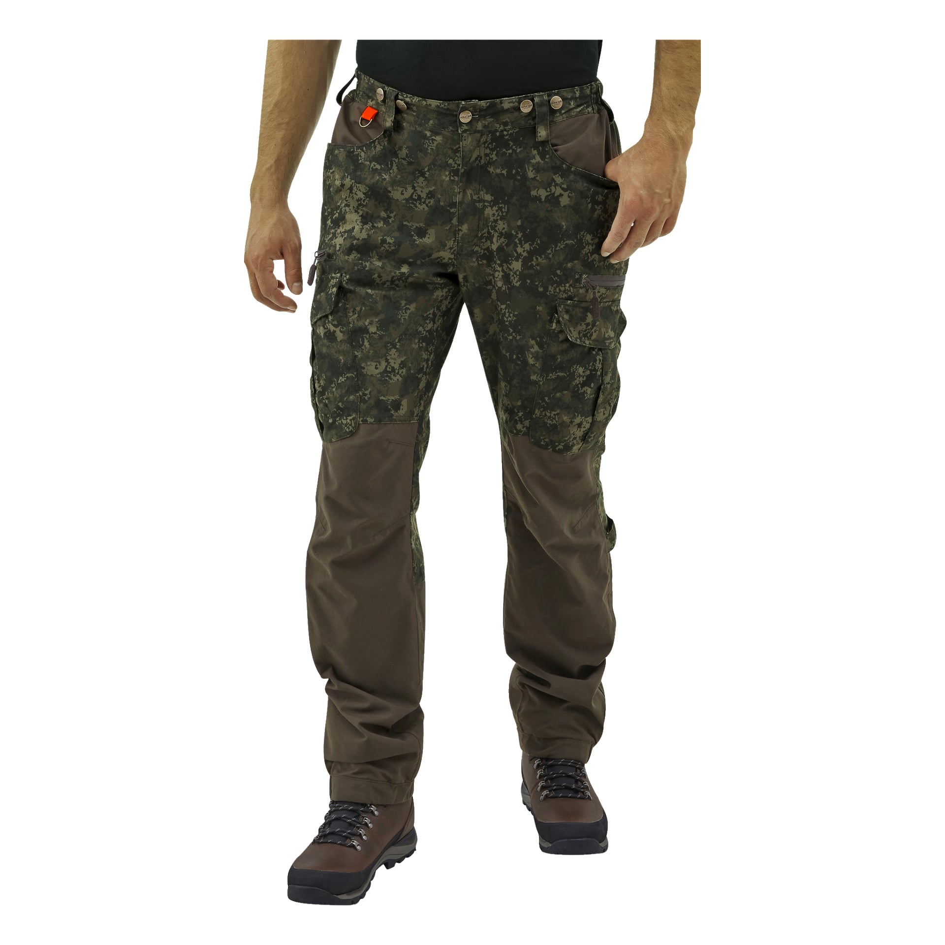 En person klädd i Kayoba Outdoor Men's Cannock Superior jaktbyxor med mörkt kamouflagemönster och bruna förstärkta detaljer, tillsammans med utomhusstövlar. Deras händer vilar nära fickorna.