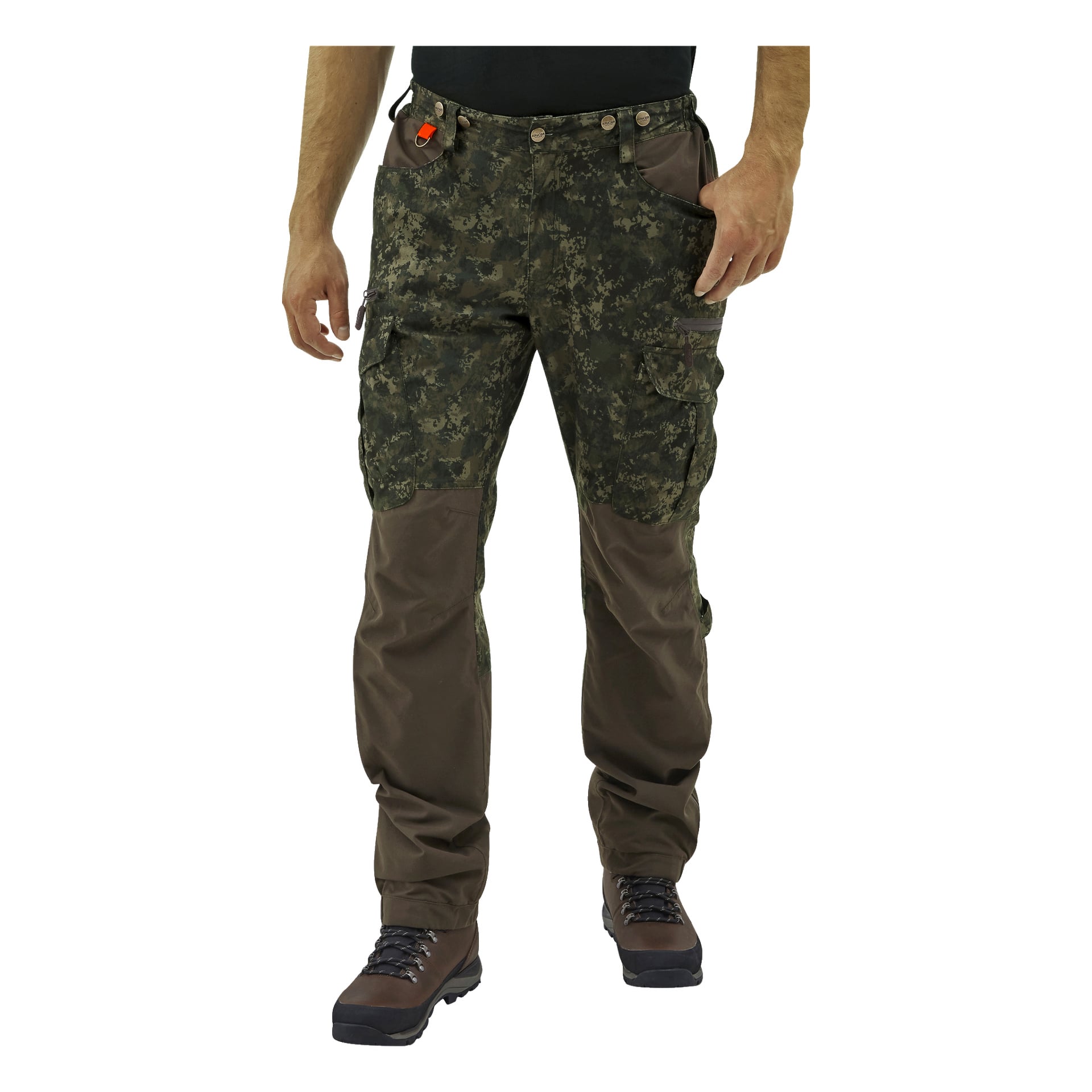 Man modellerar Kayoba Outdoor Men's jaktbyxor Cannock Superior, som har ett grönt kamouflagemönster på överdelen och brunt material under knäna. De har också bruna vandringskängor och en svart skjorta. Deras händer vilar vid sidorna, och ett litet orange föremål är fäst vid en av deras bältesöglor.