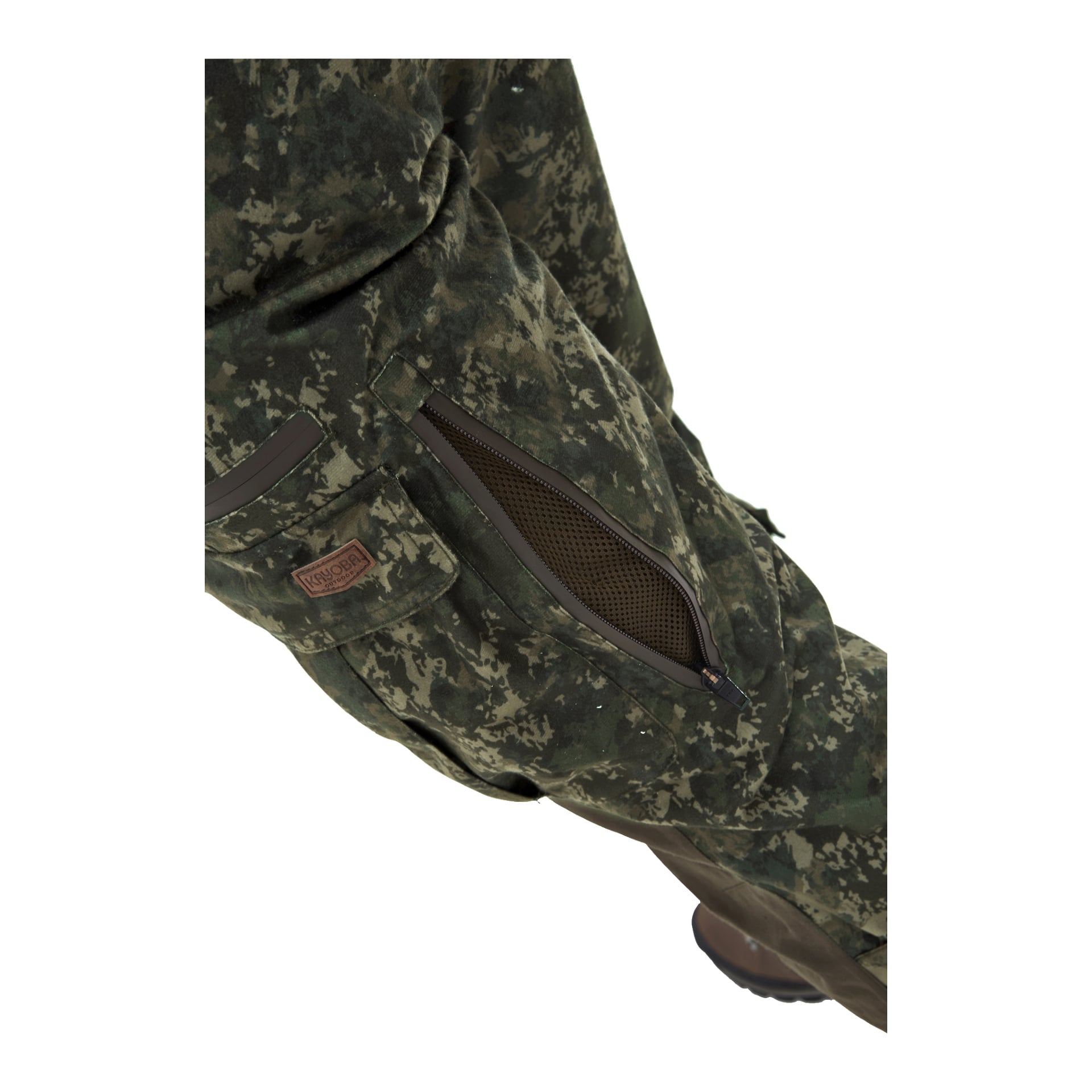 En närbild visar en person som bär Kayoba Outdoor Men's Cannock Superior jaktbyxor i grön kamouflage. Byxorna har en brun ficka med dragkedja som är delvis öppen, vilket visar nätmaterial inuti. Bredvid fickan finns en liten rektangulär lapp med text.
