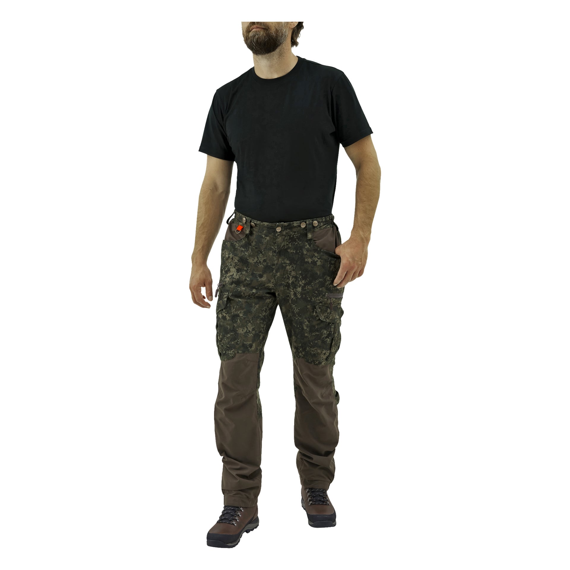 En skäggig man står framåt med armarna avslappnade längs sidorna, klädd i en enkel svart t-shirt, bruna vandringskängor och Kayoba Outdoor Men's Cannock Superior jaktbyxor med kamouflagemönster och bruna fläckar på knäna.