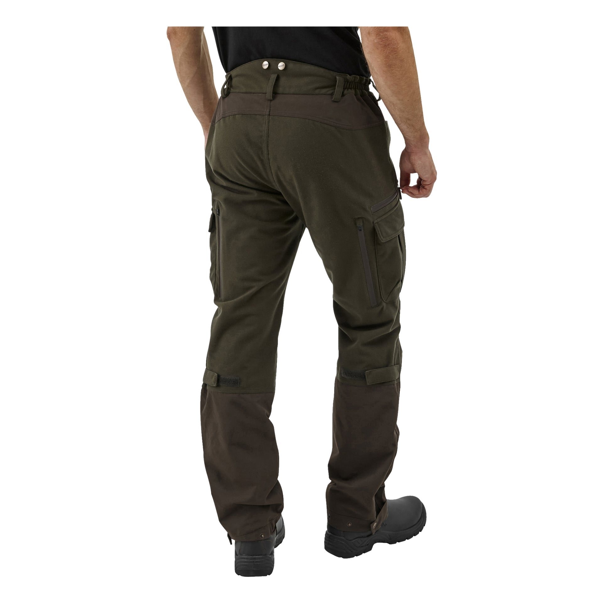 En person syns bakifrån, iklädd Kayoba Outdoor herr Cannock Superior jaktbyxor i mörkgrönt och brunt med cargofickor, matchande svarta stövlar och en svart skjorta.