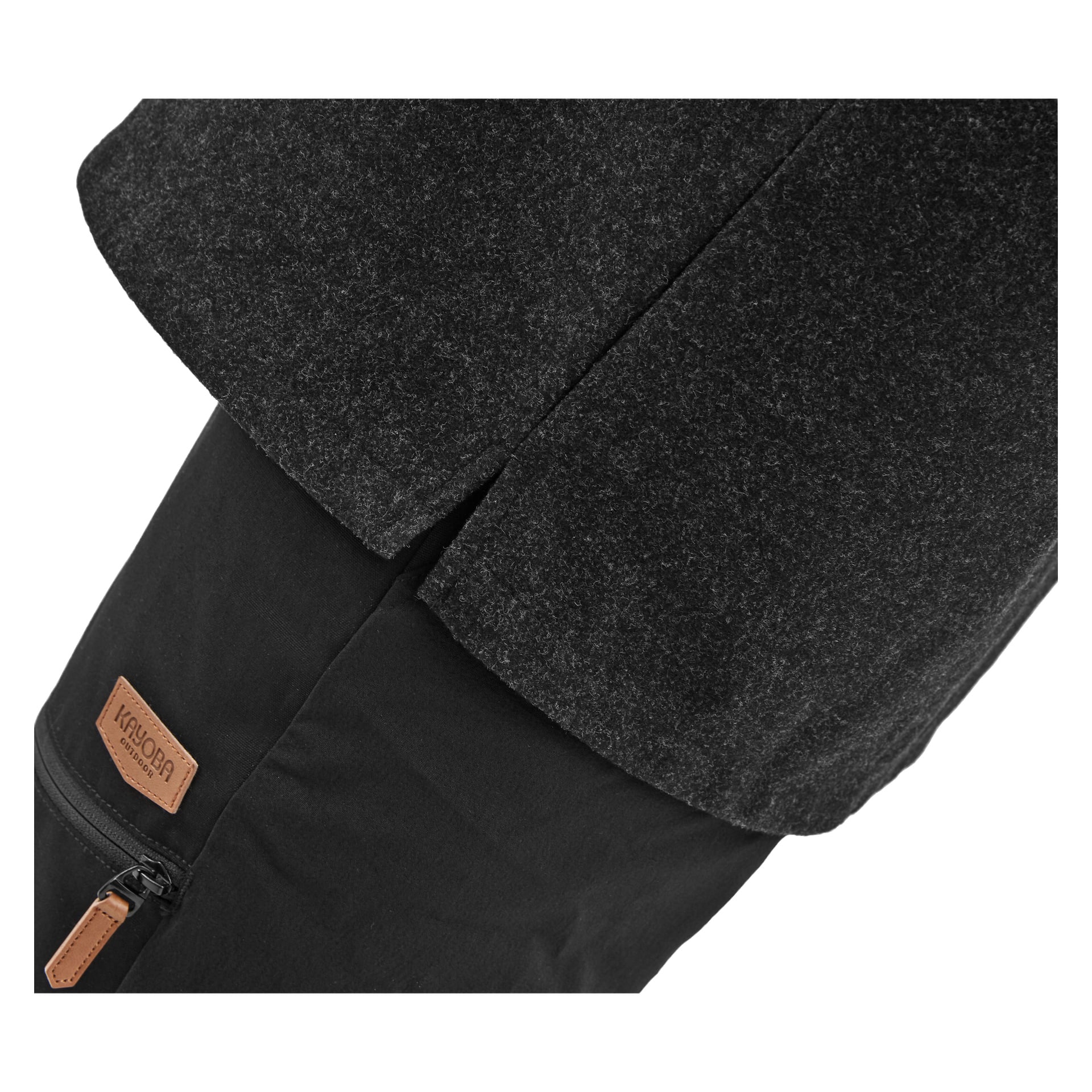 Et nærbilde viser en person i Kayoba Outdoor Overshirt for menn Idhult, mørkegrå, over svarte bukser. Bildet fokuserer på en brun lærlapp ved glidelåslommen og viser den detaljerte teksturen i stoffet.