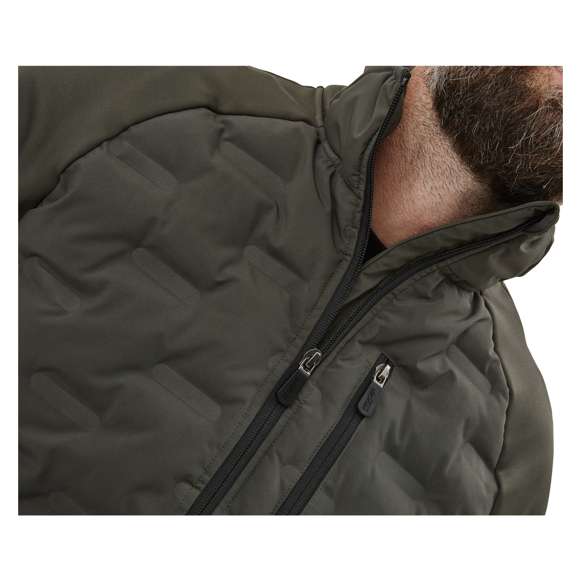 En närbild med fokus på en mans överkropp visar honom i Kayoba Outdoor Men's Särna hybridjacka, mörkgrå till färgen. Jackan har hög krage, dragkedja framtill och ett tydligt quiltat mönster med detaljerad söm. Endast hans skägg är synligt eftersom större delen av hans ansikte är utanför bilden.