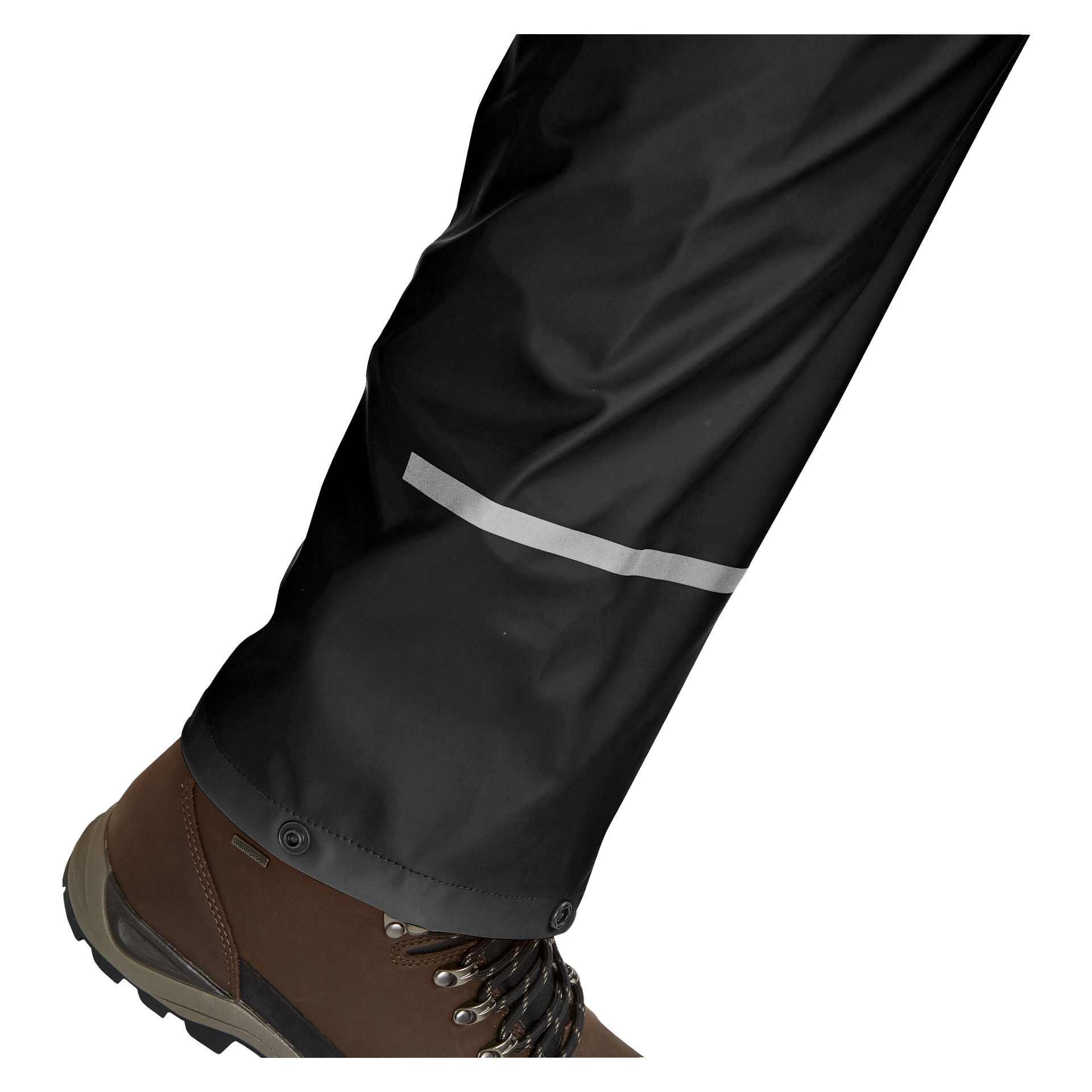 Eine Nahaufnahme von Seiten des Unterschenkels einer Person zeigt sie in Bluewear Regenanzug, schwarze Regenhosen mit reflektierendem Streifen und braune Wanderschuhe.