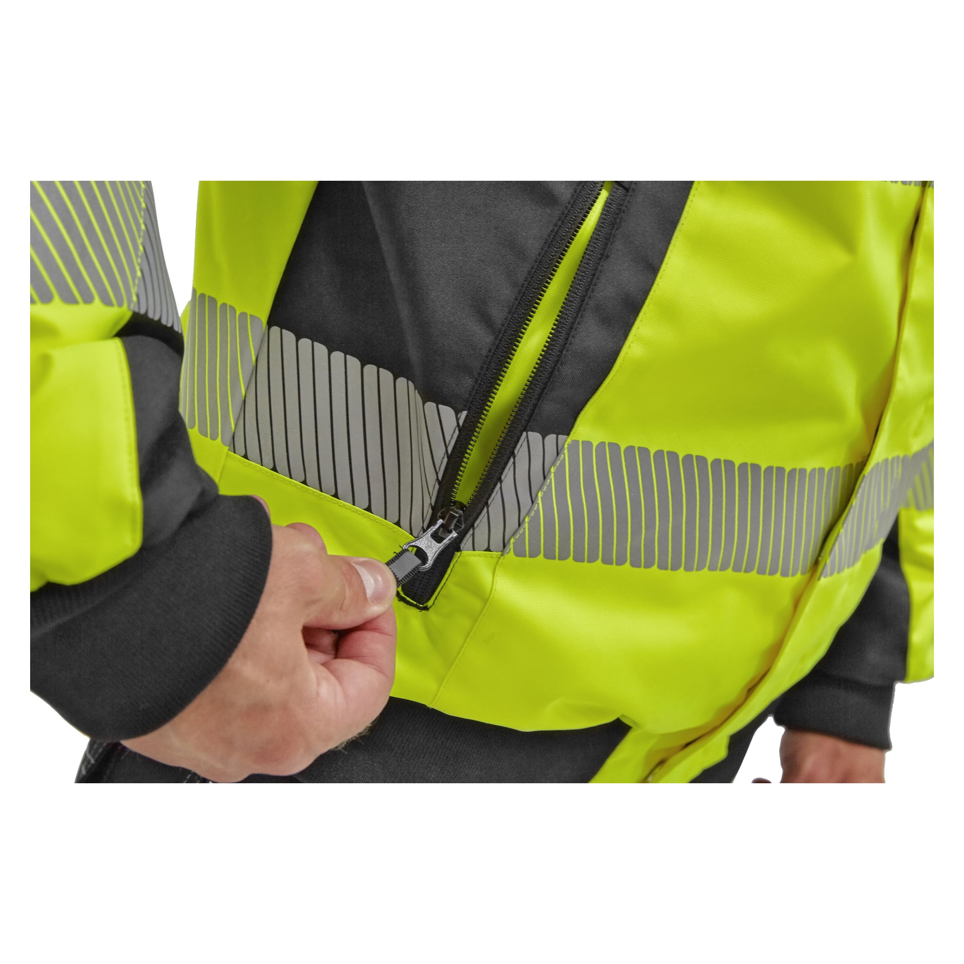 En hand visas dra upp dragkedjan på en Hi-Vis Hamilton-jacka med Bluewear Warm-foder, som är gul och svart med grå reflekterande ränder. Bilden visar bara handen, en del av armen och jackan.