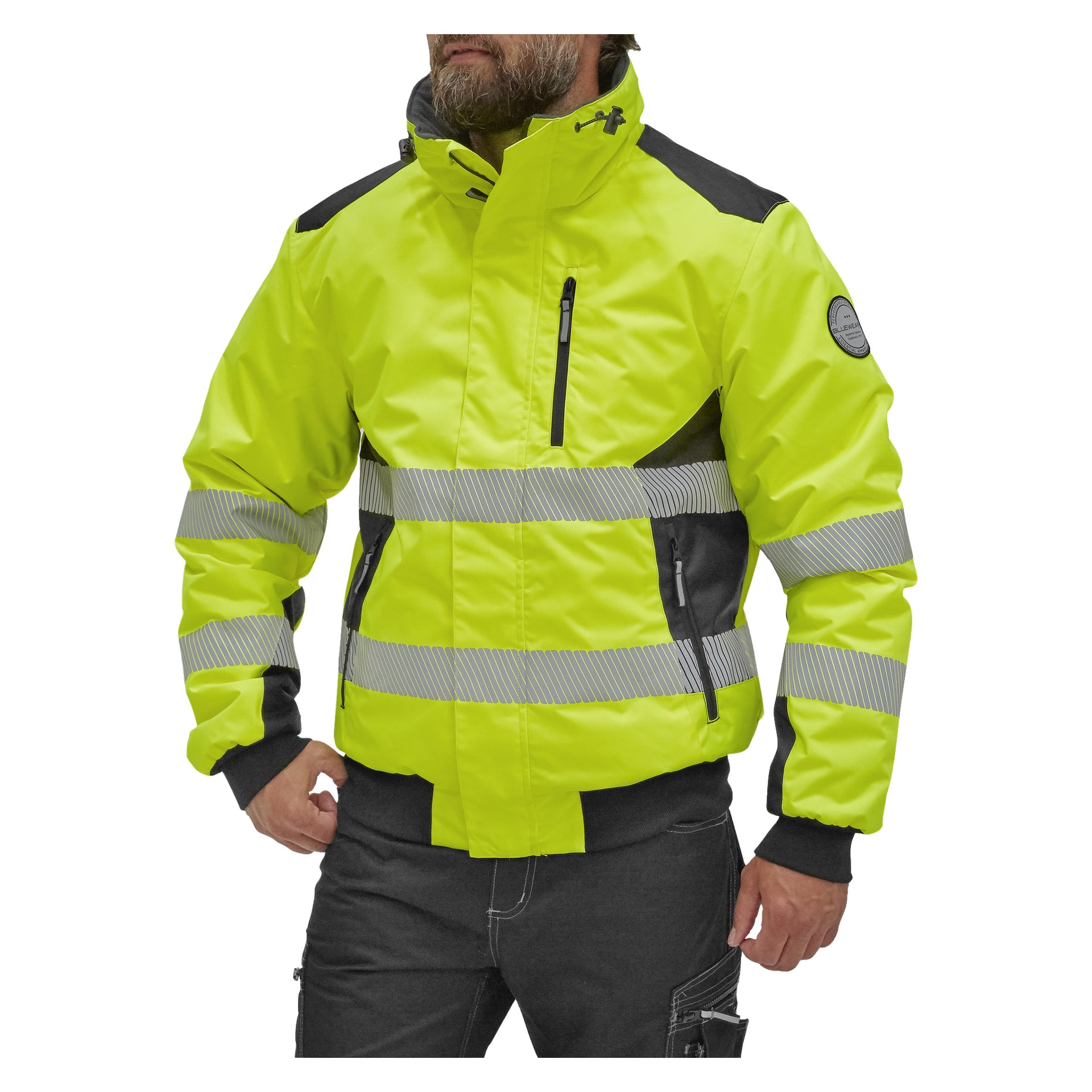 En person syns från midjan och uppåt iförd en Bluewear Warm fodrad Hi-Vis-jacka Hamilton. Jackan är klargul med reflekterande horisontella ränder, svarta detaljer, fickor med dragkedja, upphöjd krage och en lapp på vänster ärm.