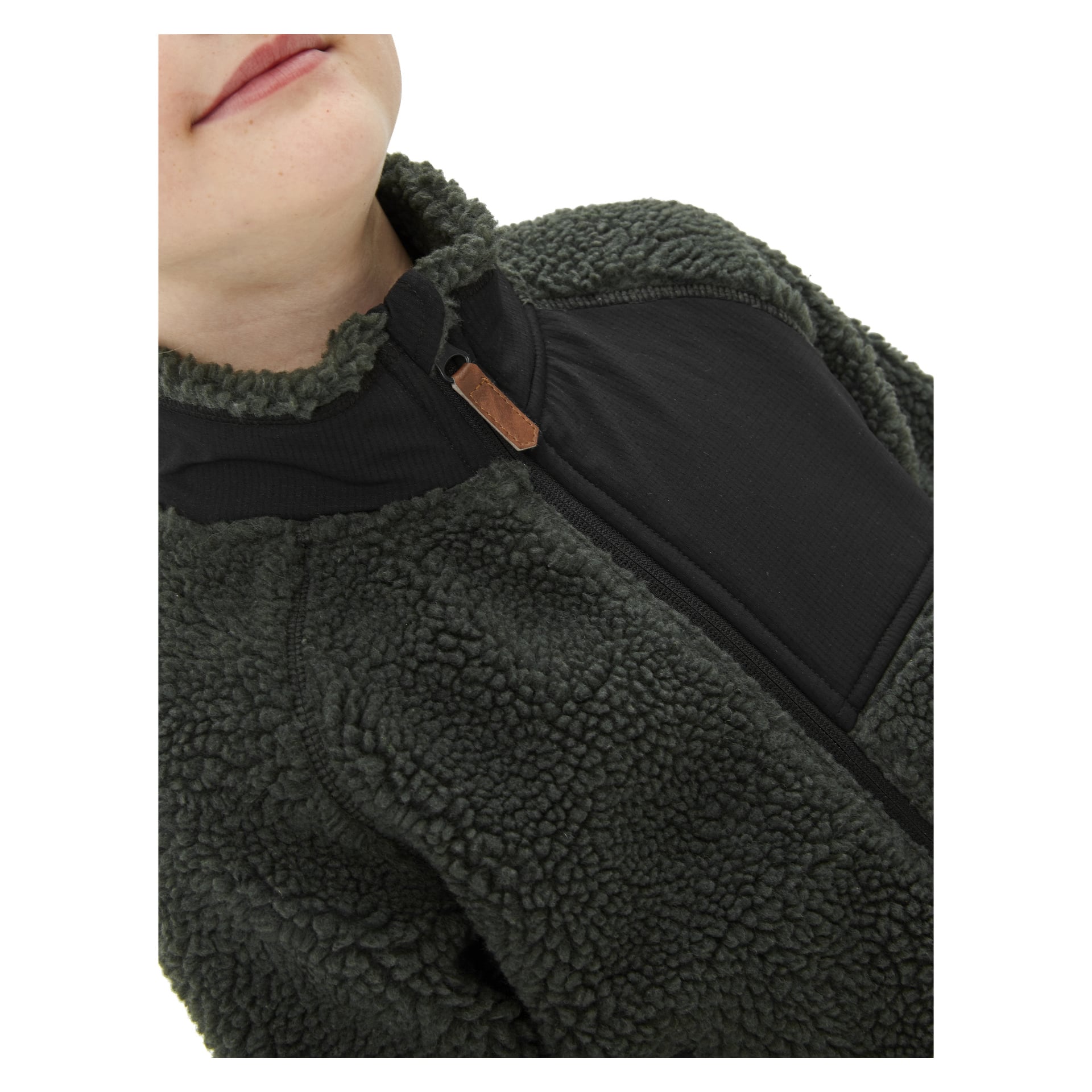 En närbild på ett barn klädd i Kayoba Outdoor Children's pilejacka, med mörkgrön texturerad fleece och en kontrasterande svart bröstpanel och dragkedja. Bilden visar bara den nedre delen av ansiktet och övre bålen.