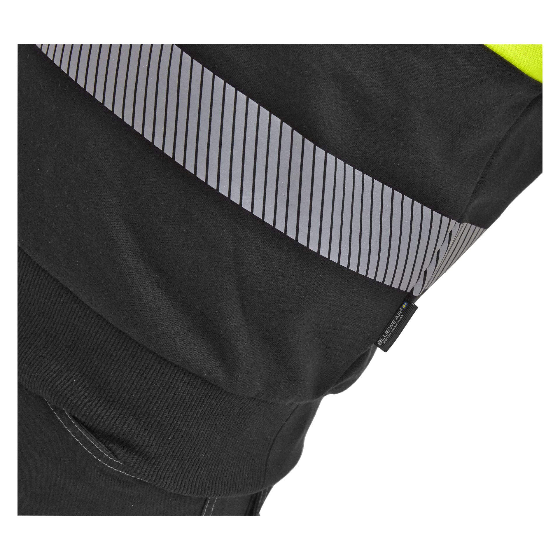 En detaljerad vy av Bluewear Hi-vis-sweatshirten Vancouver framhäver en ribbad mudd, en diagonal reflekterande rand och en liten svart lapp sydd i sömmen, med starkt neongult tyg på den övre kanten.