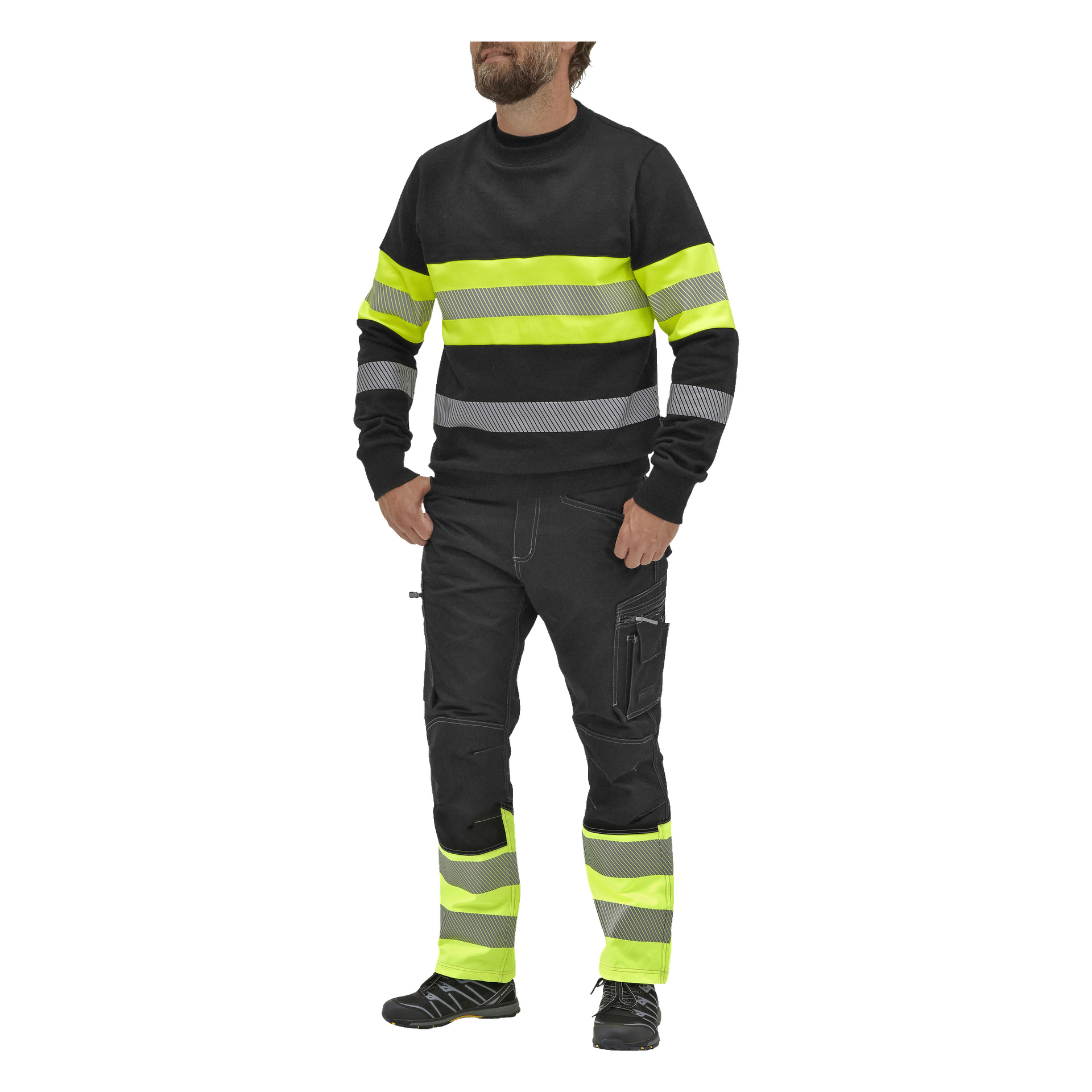 En person står med händerna i fickorna, klädd i Bluewear Hi-vis Vancouver-tröjan med klara gula och grå reflekterande ränder på ärmar, bröst och ben. Outfiten kompletteras med svarta arbetsskor.