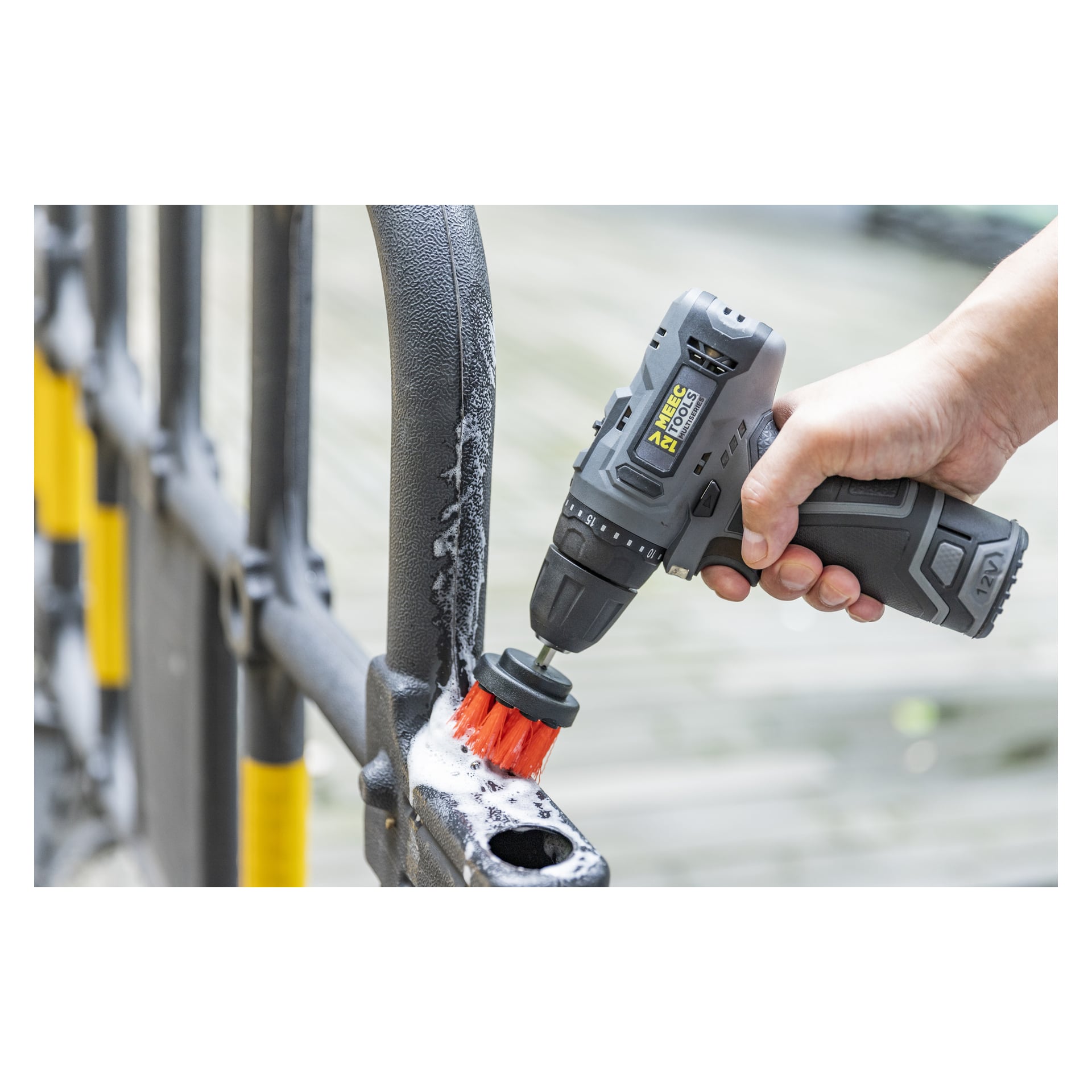 Någon rengör ett tvåligt metallräcke med Meec Tools Brush-setet för skruvmejslare (3-delat).