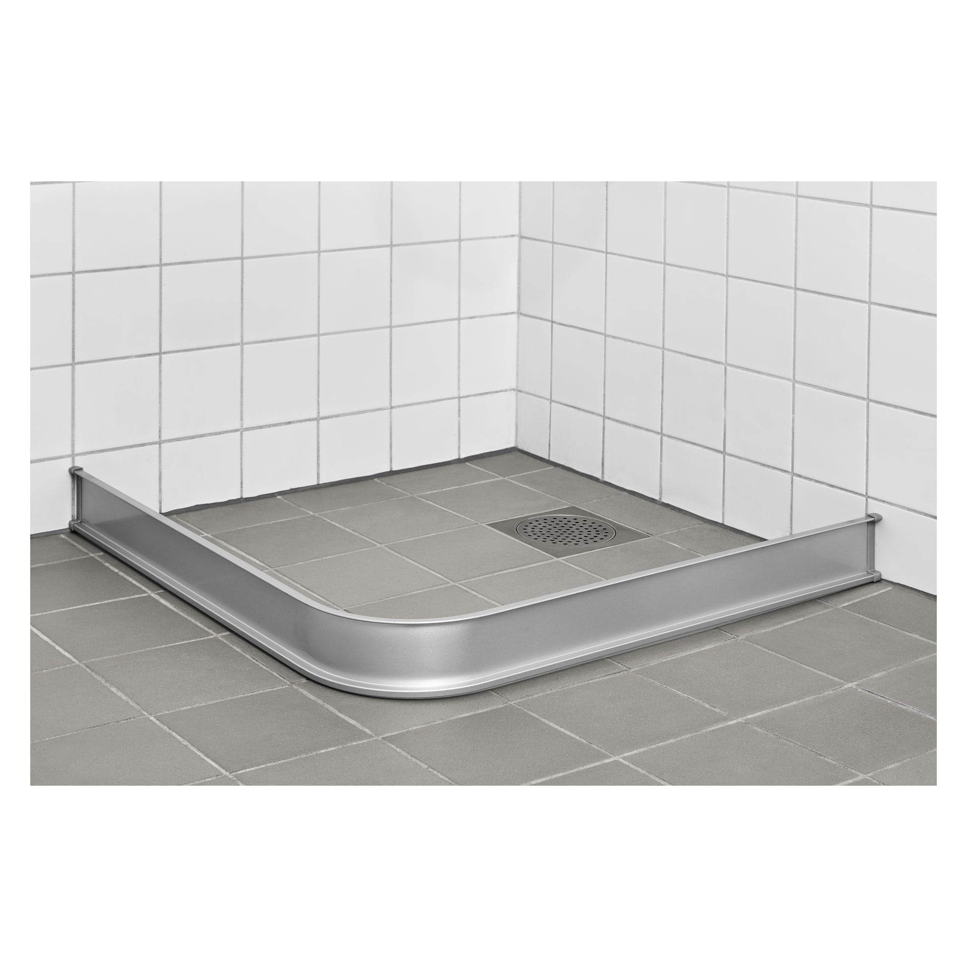 Ett duschgolv med vita kakelplattor, ett fyrkantigt avlopp i ett hörn och en EKVIP duschvattenpropp. Stoppet har en böjd metallbarriär som löper längs golvets kant.