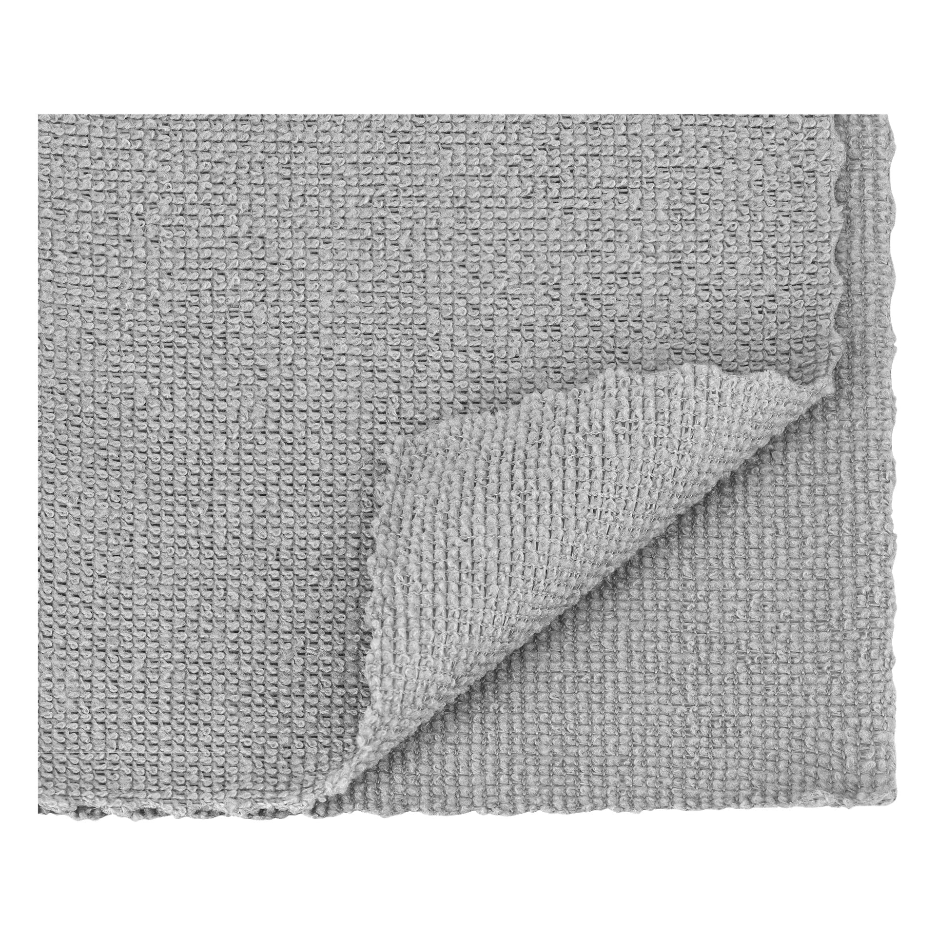 En närbild på ett Hamron Microfibre cloths 50-pack visar ett grått fyrkantigt tyg med vågiga kanter och ett hörn vikt, vilket visar samma tyg på båda sidor.