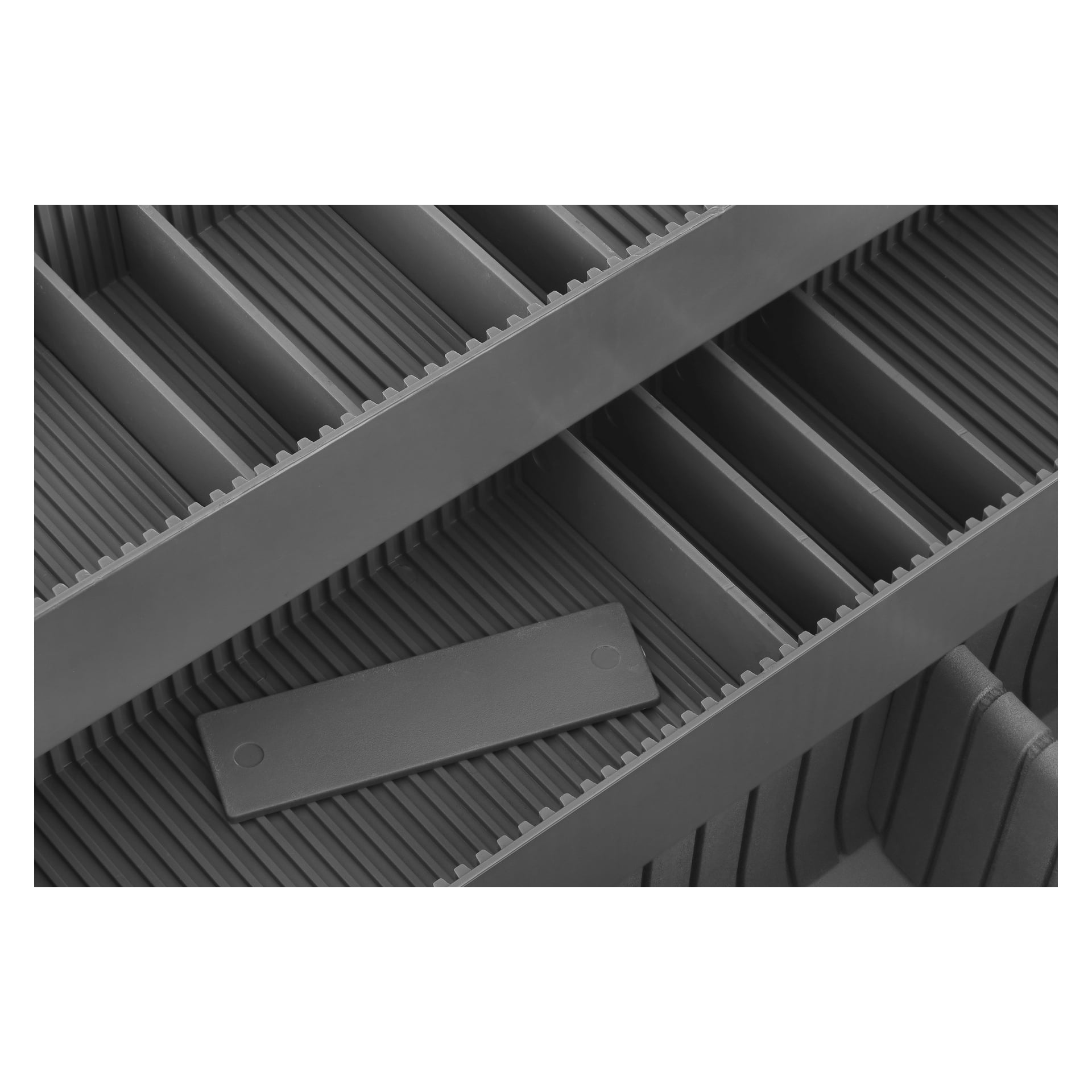 Detaljerad närbild av Hard Head Aluminium-fodralet som visar flera tomma grå fack separerade av vertikala avdelare för prydlig organisering. En avtagbar avdelare ligger plant och sträcker sig över två intilliggande fack.