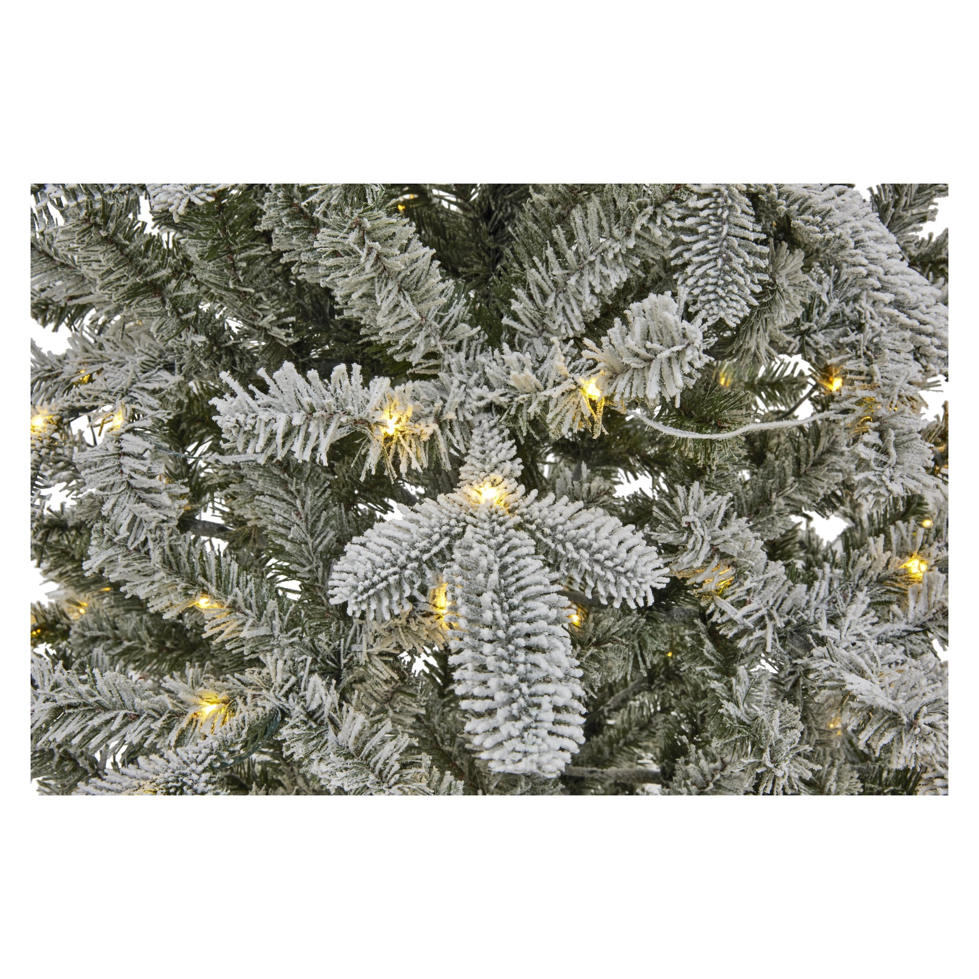 Detaljerad vy av EKVIP Lifelike Christmas Tree som visar snötäckta konstgjorda tallgrenar med ett mjukt lager av vit flock och delvis glödande varma LED-lampor i bakgrunden.