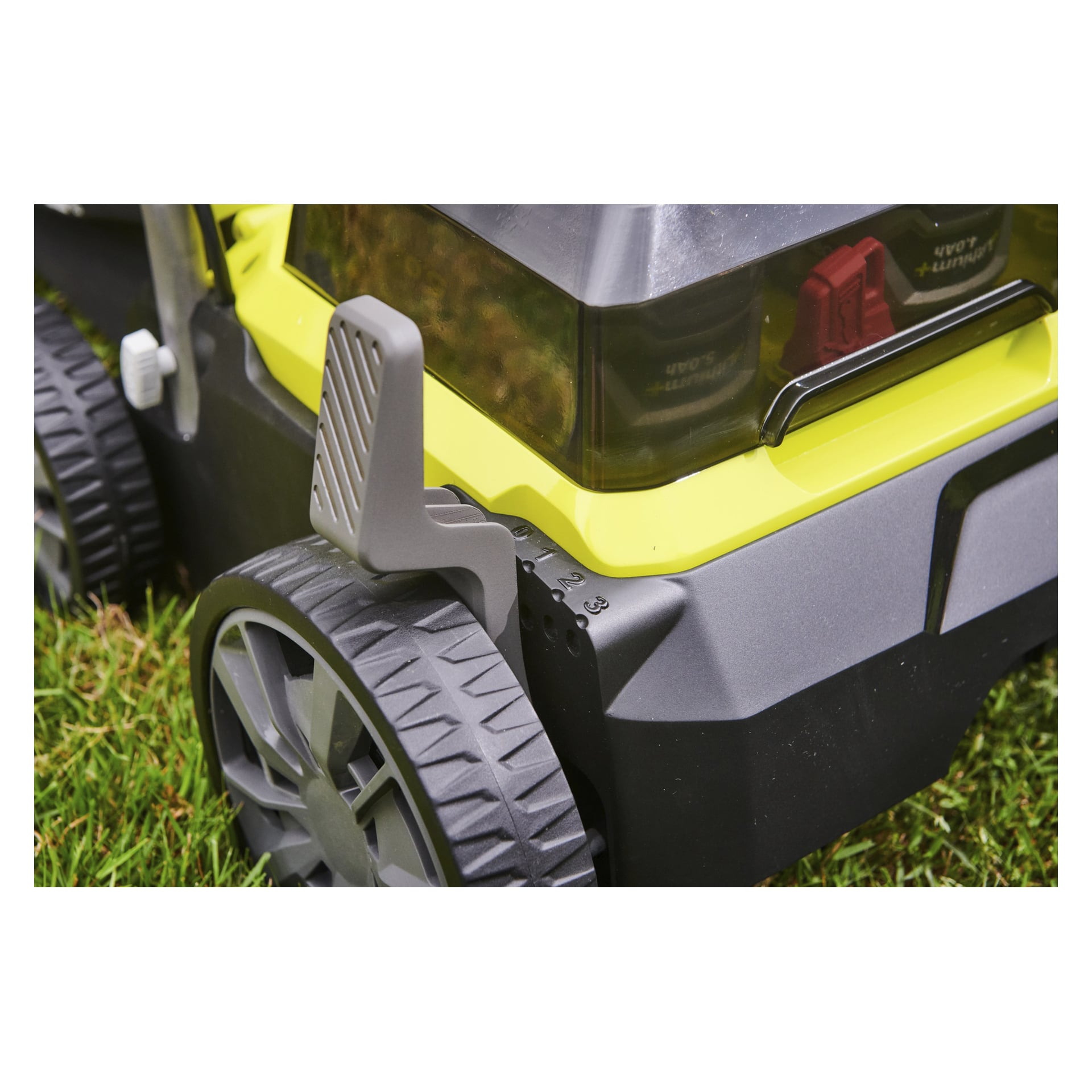 En detaljerad vy av Ryobi One+ batteridrivna verticutter RY18SFX35A-0 visar bakhjulet, höjdjusteringsspaken och en del av maskinens kaross. Klipphöjden är tydligt synliga när den står på grönt gräs.