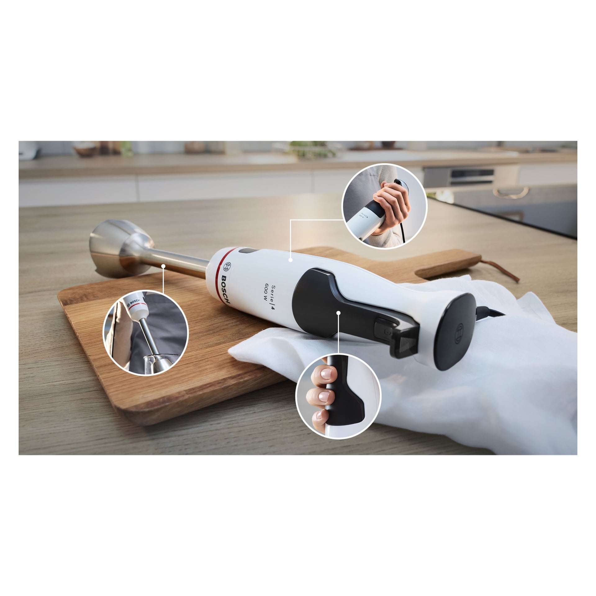 Ein Bosch Home Hand Blender ErgoMaster MSM4W220 in Weiß und Schwarz steht auf einem Holzschneidebrett. Drei kreisförmige Nahaufnahme-Einsätze heben den Power-Knopf, den ergonomischen Griff und die Stelle, an der der Blending-Befestigung ankommt.