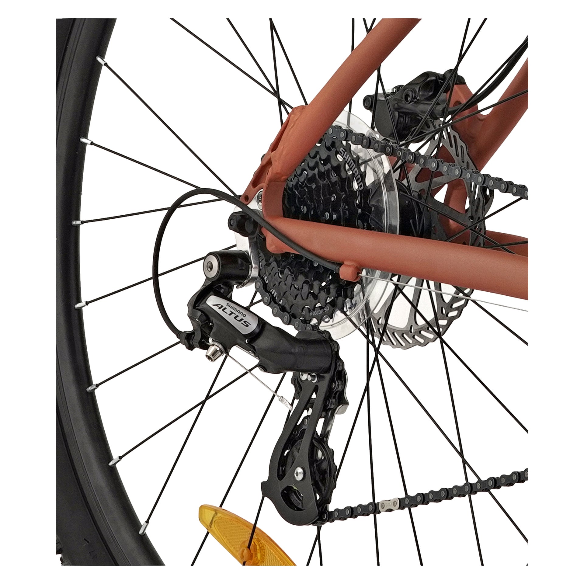 Detaljerad vy av bakhjulet på Kayoba Freedom 3 mountainbike, där växellådan, kassetten, skivbromsskivan och kedjan visas mot en slående orange ramsektion. Det knöliga däcket är tydligt synligt tillsammans med en gul ekreflektor.