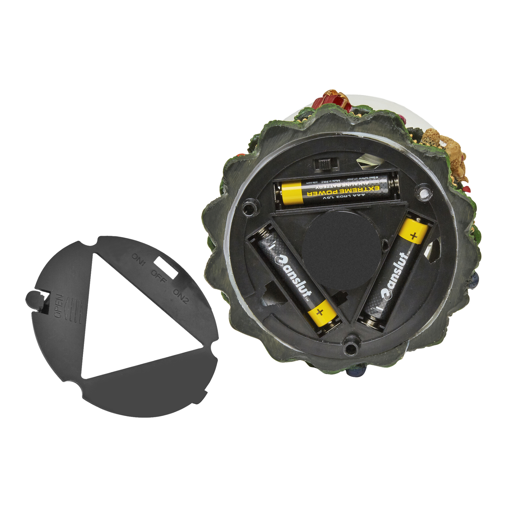 Undersidan av EKVIP Musical-snögloben med LED-lampor visar ett öppet batterifack som rymmer tre AA-batterier, medan det borttagna locket som visar ON, OFF och ON2-brytare ligger bredvid globen.