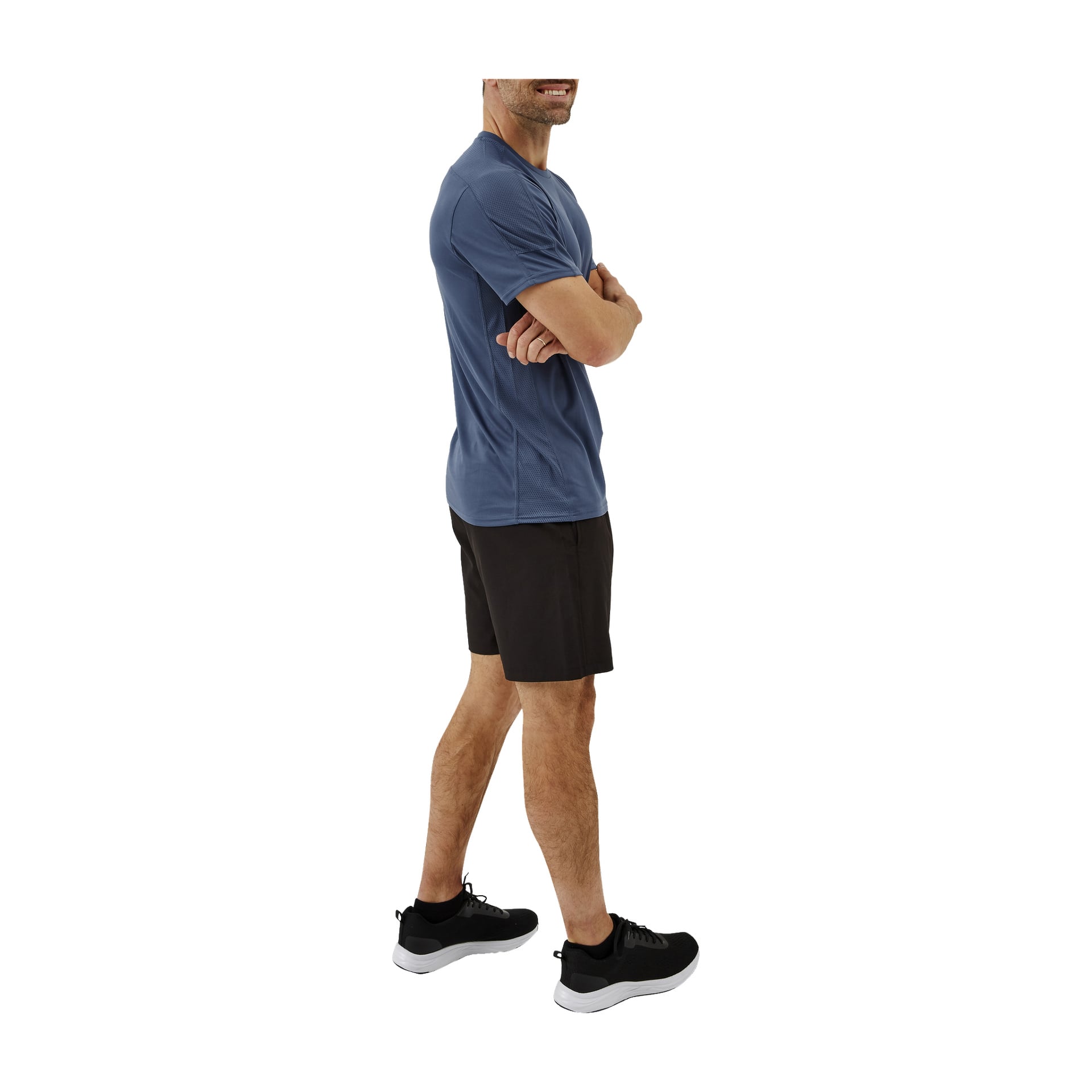 En kvinna med armarna i kors bär en Kayoba funktionell damtopp, svarta shorts och svarta sportskor. Hennes kropp är något vriden åt sidan och hennes ansikte är delvis synligt.
