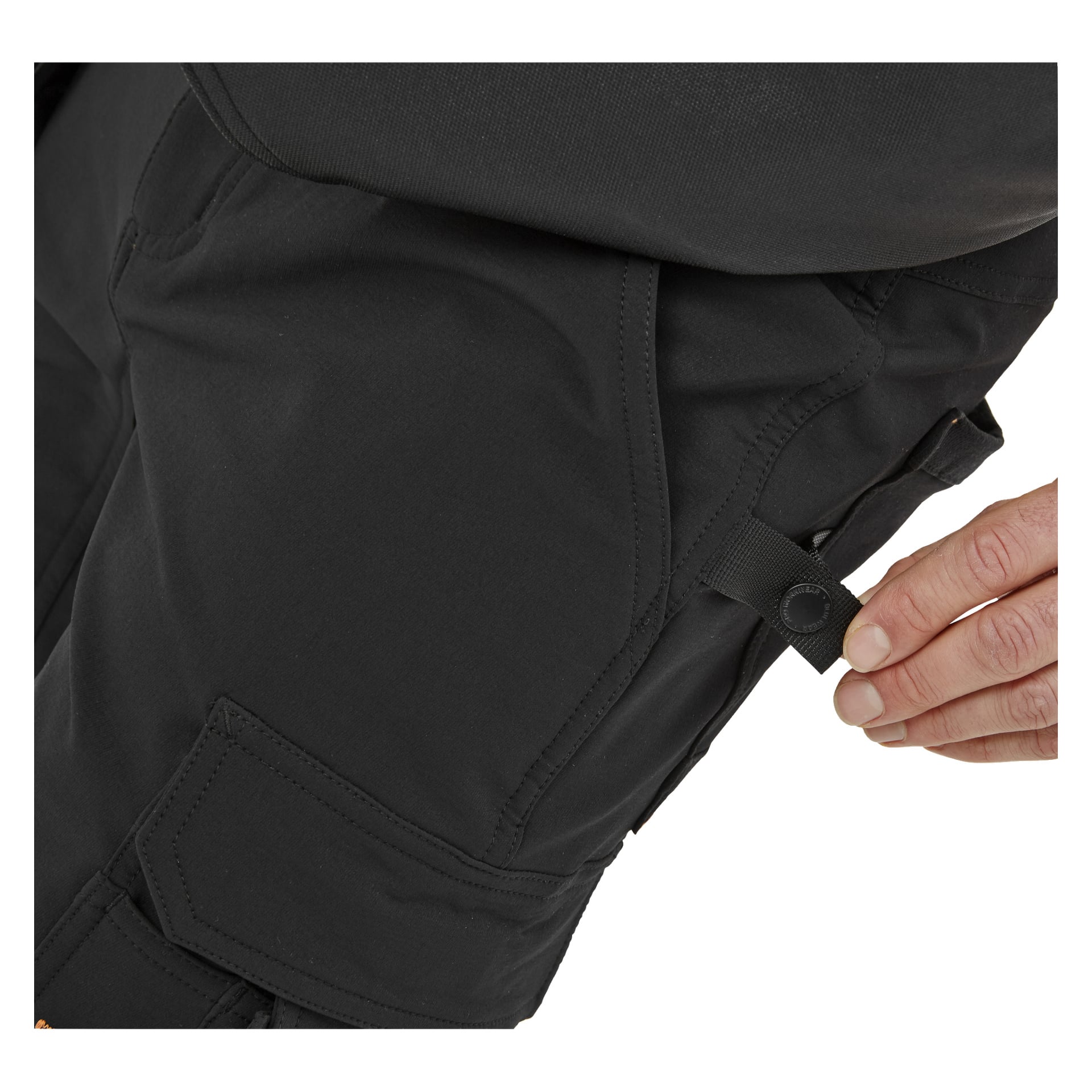 Man fäster en svart knappflik på sidan av Bluewear Pro Workwear Steve herrshorts, som har flera fickor.