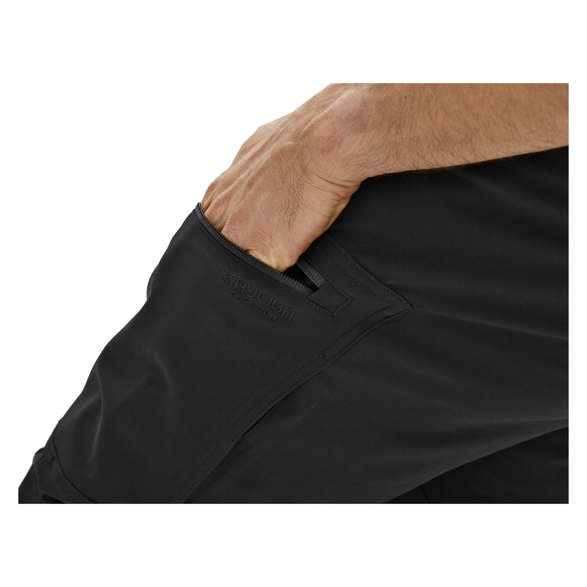 En närbild visar en hand instucken i framfickan på svarta herrbyxor Östanå från Kayoba Outdoor. Tyget ser slätt ut och är lite elastiskt, med distinkta sömmar och en diskret Kayoba Outdoor-logga nära fickkanten.