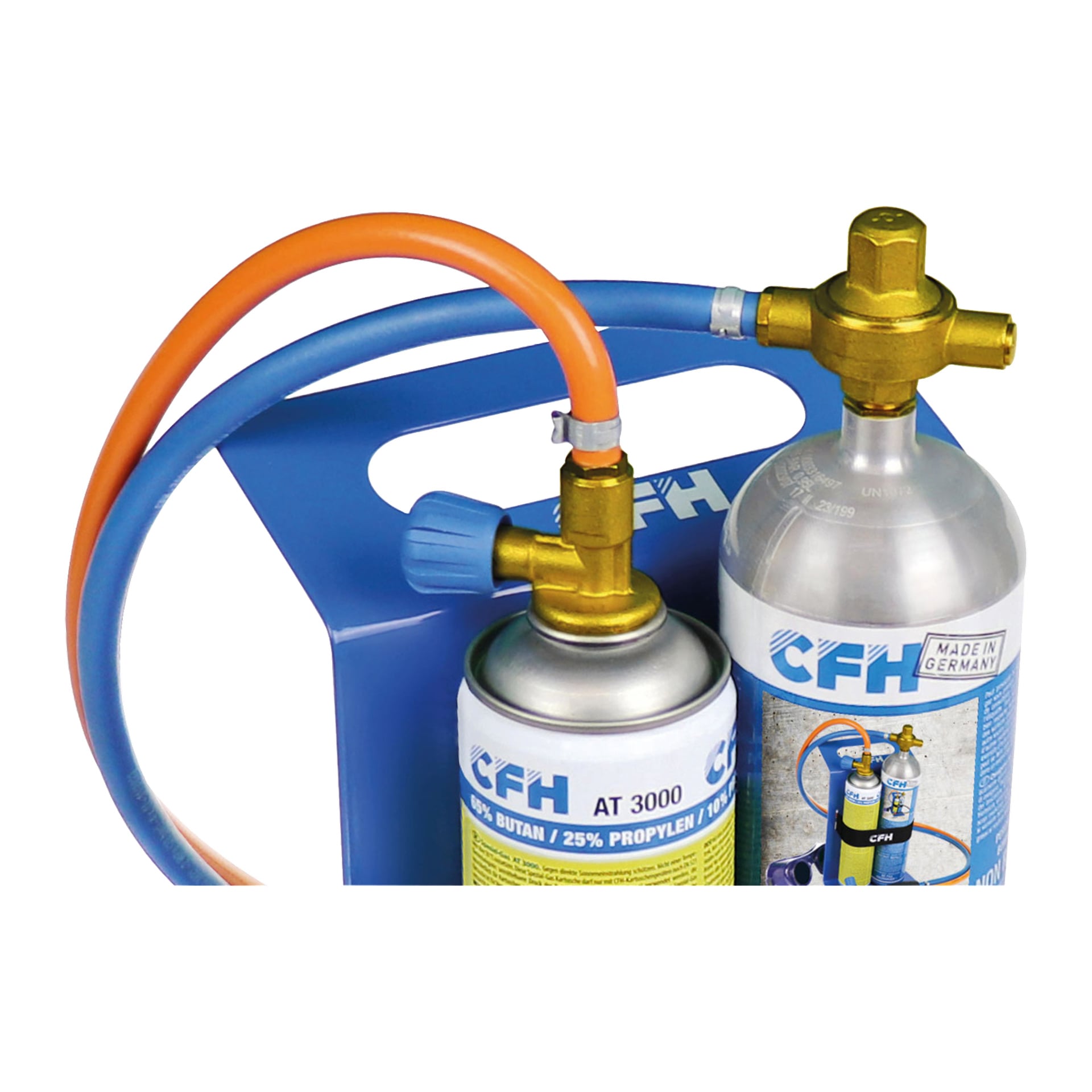 Ett par CFH-gassvetscylindrar utrustade med mässingsventiler och kopplade till orange och blå slangar, vilande på en blå bärväska. Cylinderetiketterna visar CFH-logotypen och bruksanvisningen.