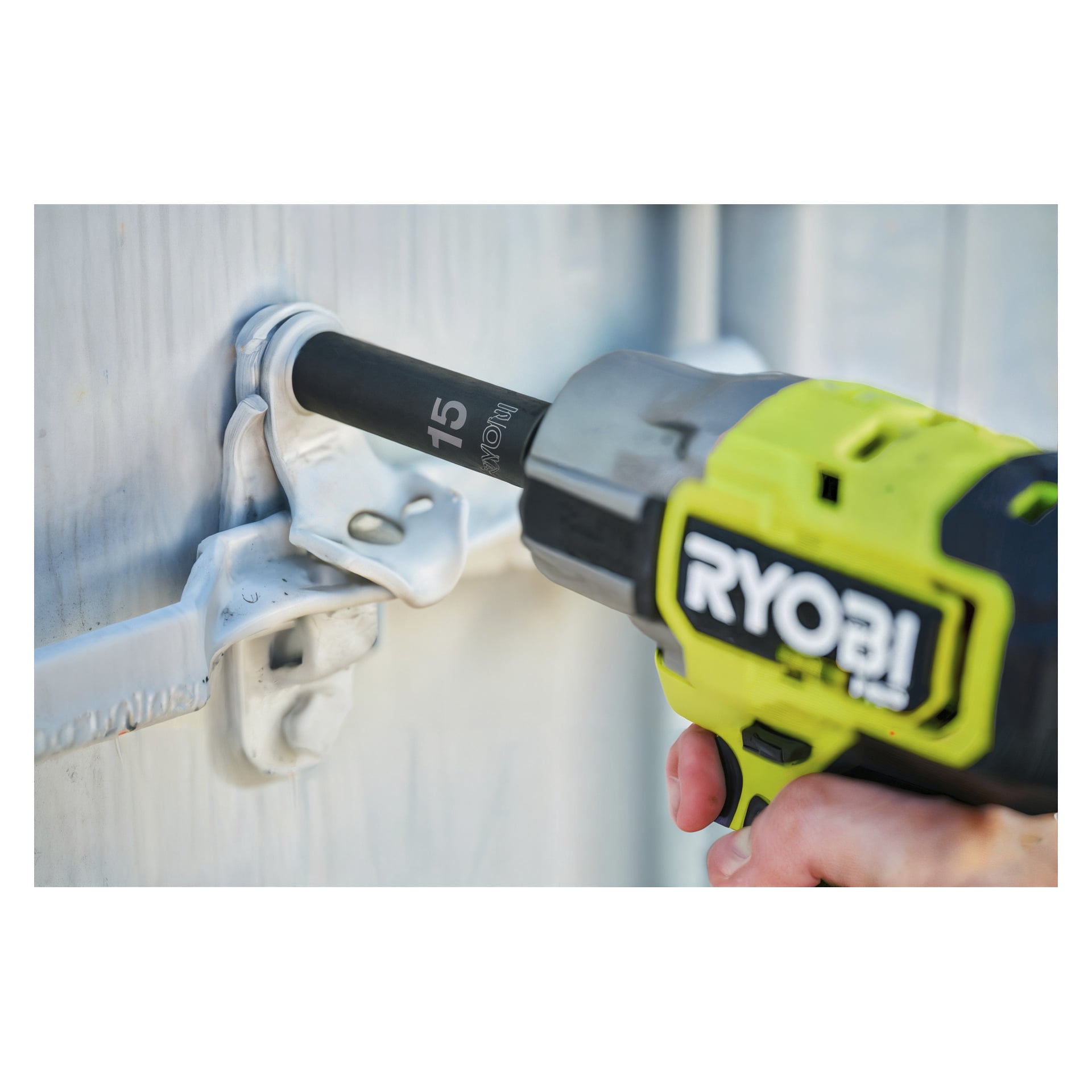 En Ryobi RHDIS10PC 10-delad hylsa med 15 mm hylsa används på en bult som fäster en metalllås i en grå metalldörr.