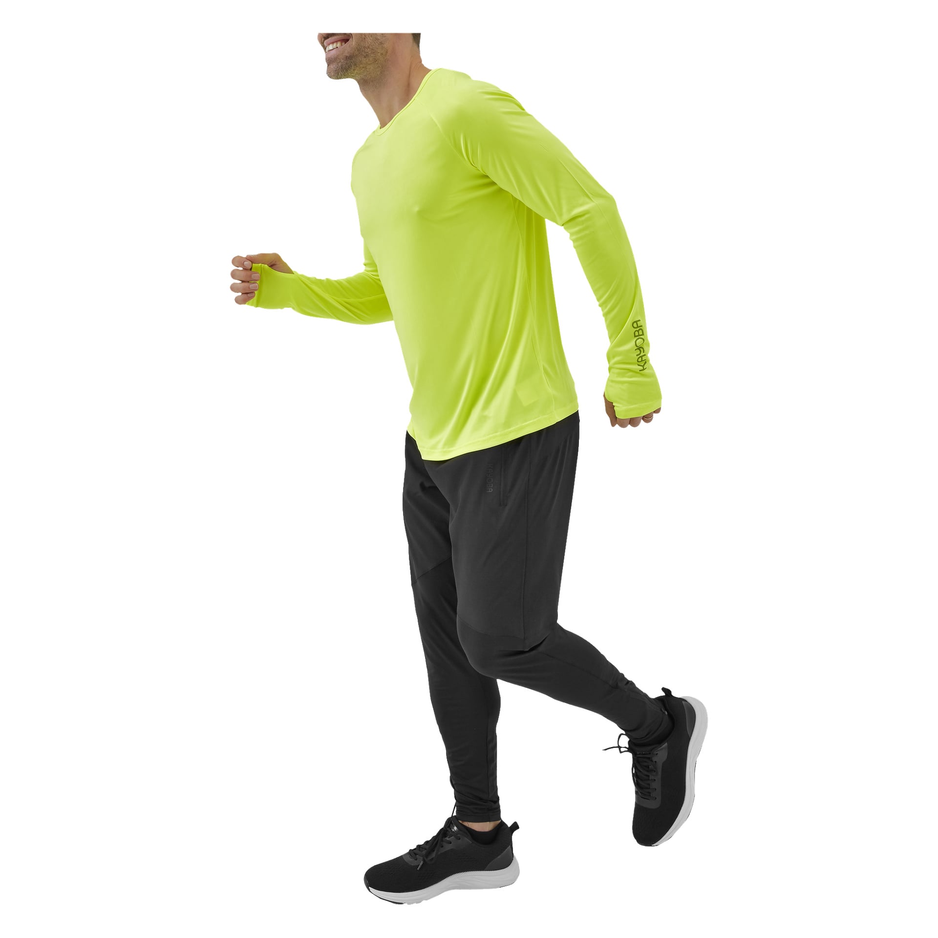 En man klädd i en klargul långärmad skjorta, svarta Kayoba Men's Functionable byxor Rio och svarta sneakers visas jogga eller springa. Fotot är beskuret vid axlarna och under knäna.