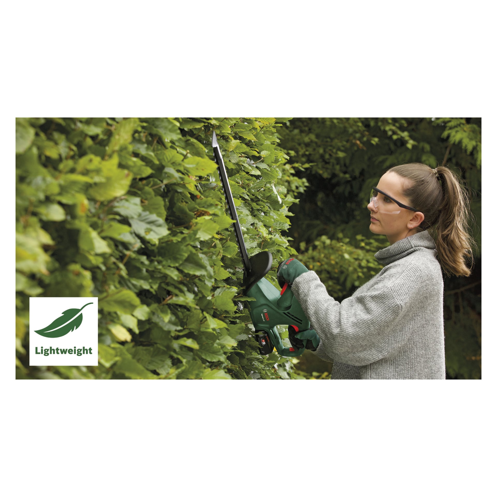 En person som bär skyddsglasögon och handskar trimmar en frodig häck med Bosch Power 4 All Battery-powered EasyHedgeCut 18-45 häcksax. I nedre vänstra hörnet finns en bladikon med ordet "Lightweight", och tjockt grönt lövverk fyller bakgrunden.