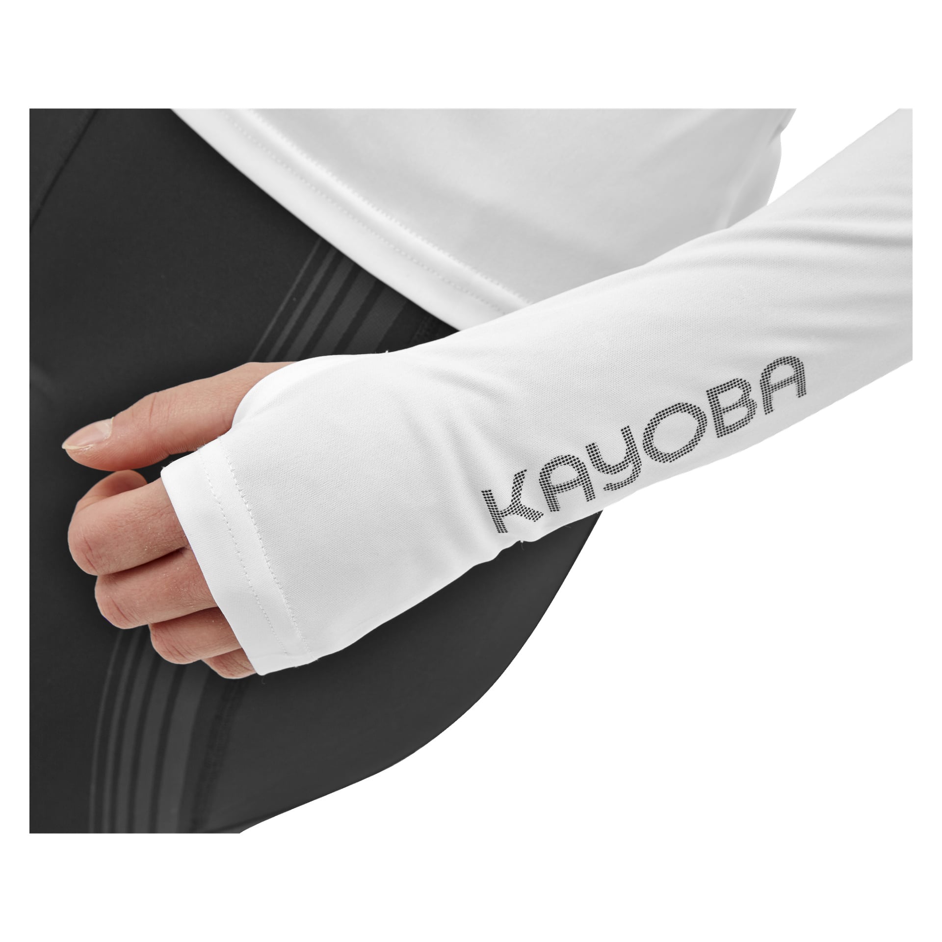 En person klädd i Kayoba Women's Atlanta långärmad atlettopp, som är vit med varumärket nere på ärmen och inkluderar ett tumhål. De bär också svarta leggings, och en del av handen syns genom tumhålet.